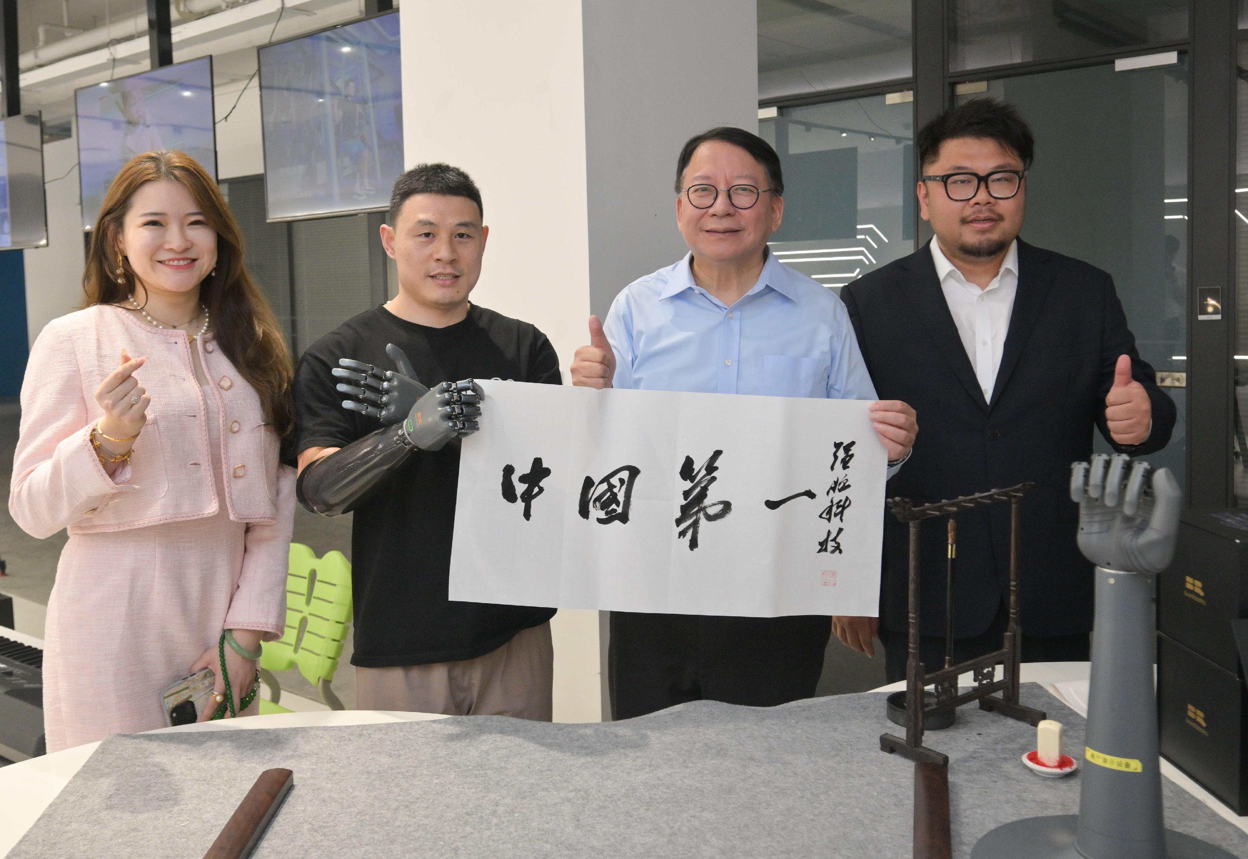 The Chief Secretary for Administration, Mr Chan Kwok-ki, continued his visit to Hangzhou today (August 13). Photo shows Mr Chan (second right) with the results from a demonstration of a smart prosthesis that can write calligraphy during his visit to a high-technology start-up, BrainCo.