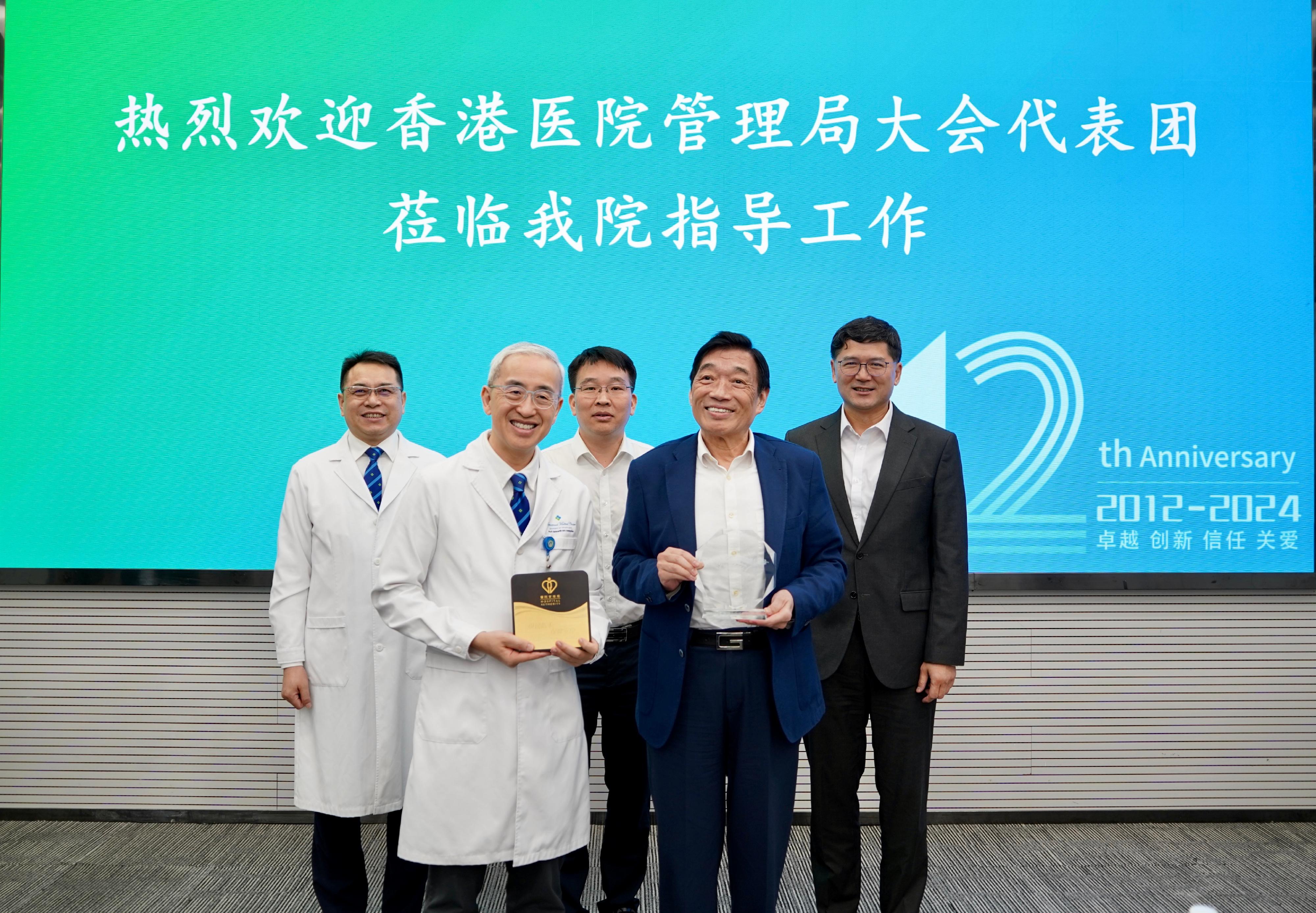 The Hospital Authority Chairman, Mr Henry Fan, led a delegation to visit the University of Hong Kong-Shenzhen Hospital this morning (August 17). Photo shows Mr Fan (front row, right) presenting a souvenir to the Chief Executive of the University of Hong Kong-Shenzhen Hospital, Professor Kenneth Cheung (front row, left). The Chief Executive of the Hospital Authority, Dr Tony Ko (back row, right), and Deputy Director General of the Shenzhen Municipal Health Commission Mr Li Chuang (back row, centre) also attended.

