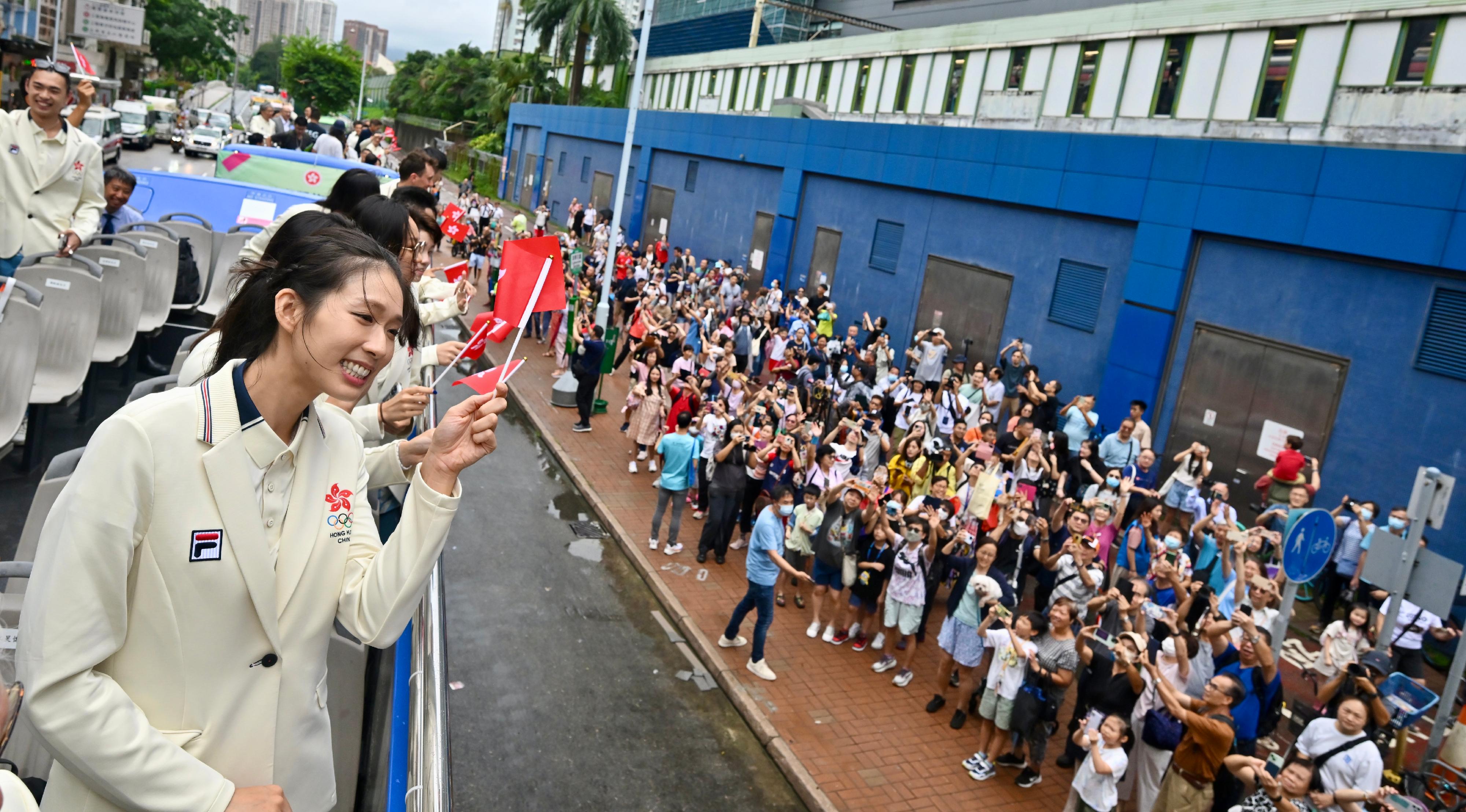 The Hong Kong Special Administrative Region Government and the Sports Federation & Olympic Committee of Hong Kong, China arranged a bus parade and Welcome Home Reception today (August 21) for the Hong Kong, China Delegation to the 2024 Paris Olympic Games. Photo shows coaches and other Delegation members in the bus parade waving at members of the public along the parade route.