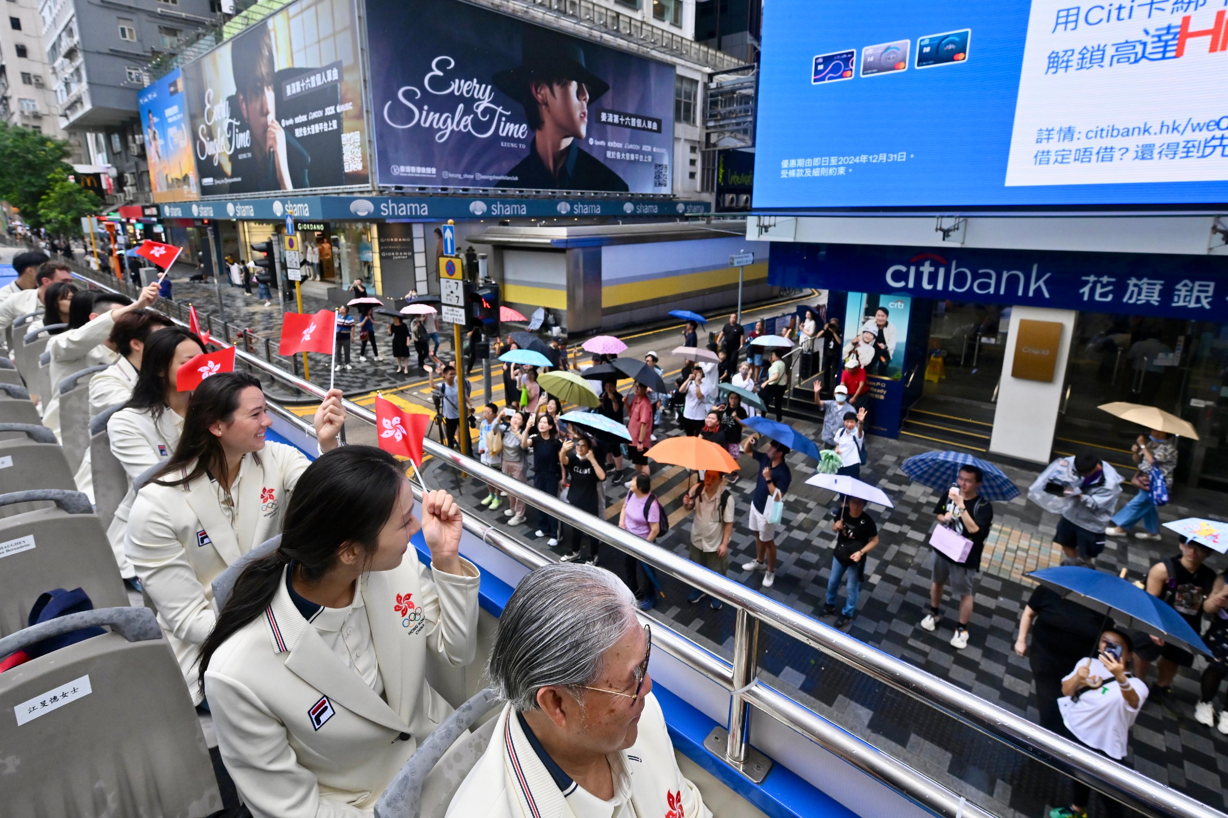 The Hong Kong Special Administrative Region Government and the Sports Federation & Olympic Committee of Hong Kong, China arranged a bus parade and Welcome Home Reception today (August 21) for the Hong Kong, China Delegation to the 2024 Paris Olympic Games. Photo shows coaches and other Delegation members in the bus parade waving at members of the public along the parade route.