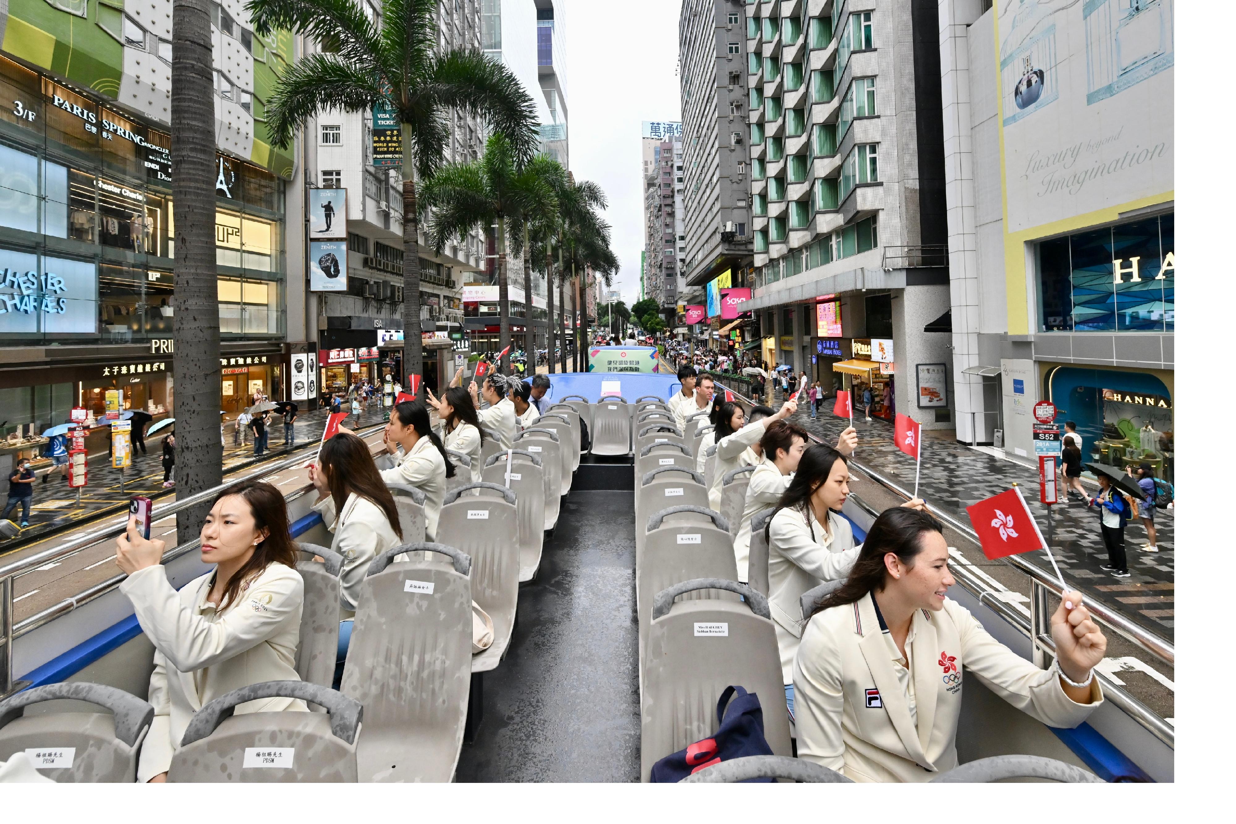 The Hong Kong Special Administrative Region Government and the Sports Federation & Olympic Committee of Hong Kong, China arranged a bus parade and Welcome Home Reception today (August 21) for the Hong Kong, China Delegation to the 2024 Paris Olympic Games. Photo shows coaches and other Delegation members in the bus parade waving at members of the public along the parade route.