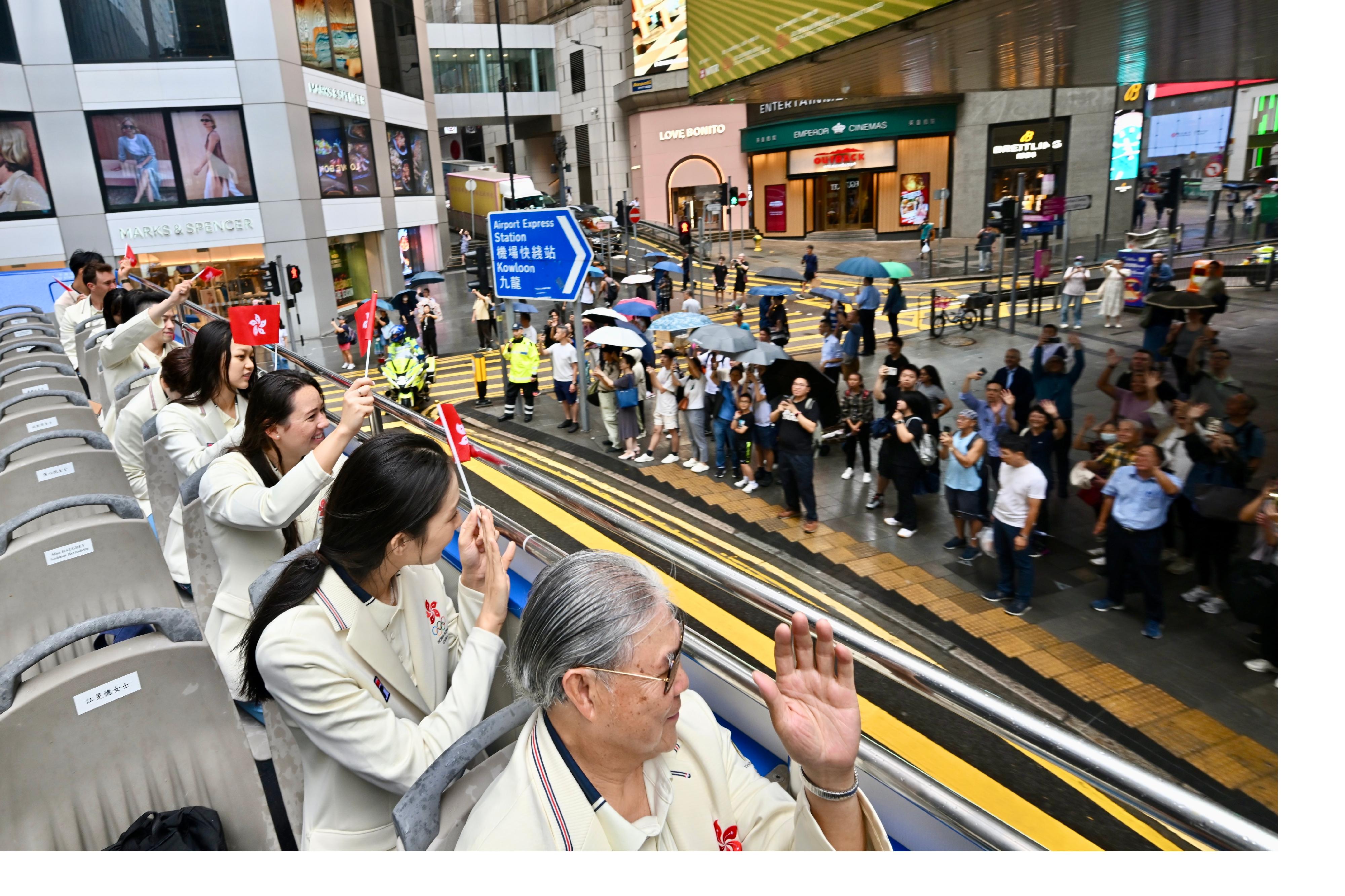 The Hong Kong Special Administrative Region Government and the Sports Federation & Olympic Committee of Hong Kong, China arranged a bus parade and Welcome Home Reception today (August 21) for the Hong Kong, China Delegation to the 2024 Paris Olympic Games. Photo shows coaches and other Delegation members in the bus parade waving at members of the public along the parade route.
