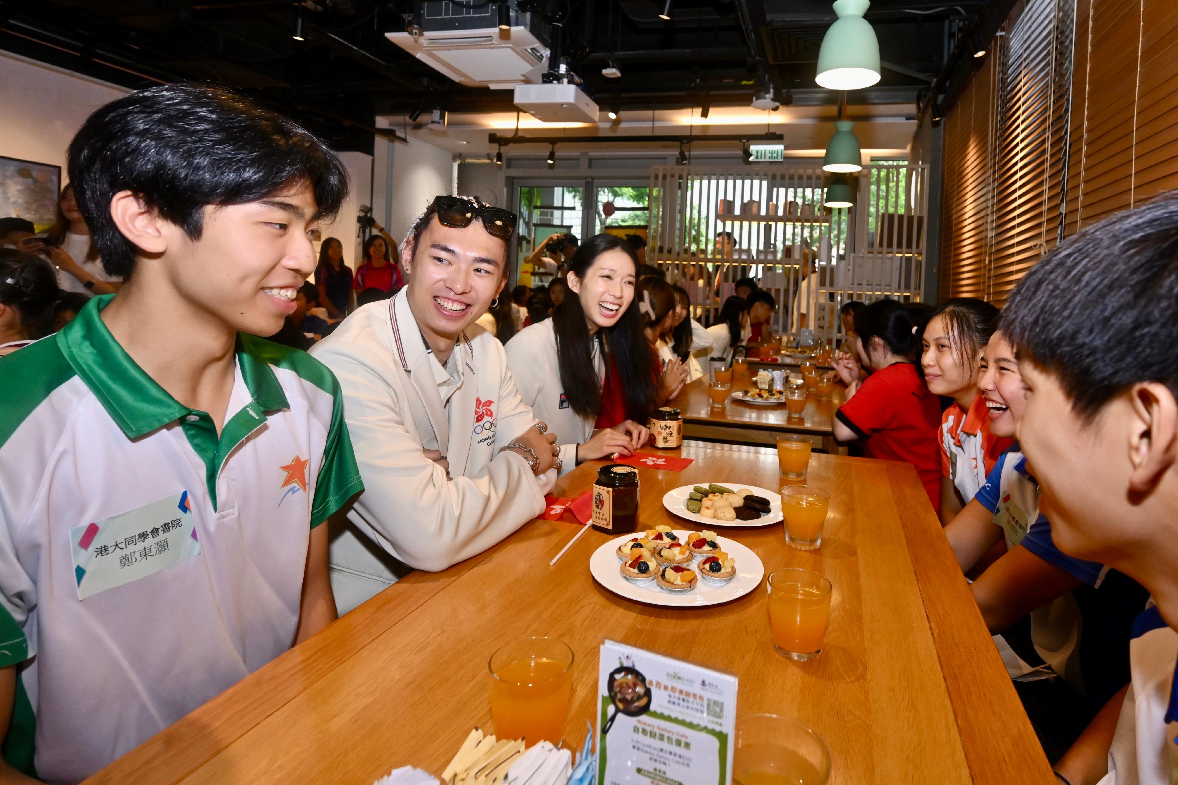 The Hong Kong Special Administrative Region Government and the Sports Federation & Olympic Committee of Hong Kong, China arranged a bus parade and Welcome Home Reception today (August 21) for the Hong Kong, China Delegation to the 2024 Paris Olympic Games. Photo shows the athletes interacting with students at iBakery upon their arrival at Tamar Park.