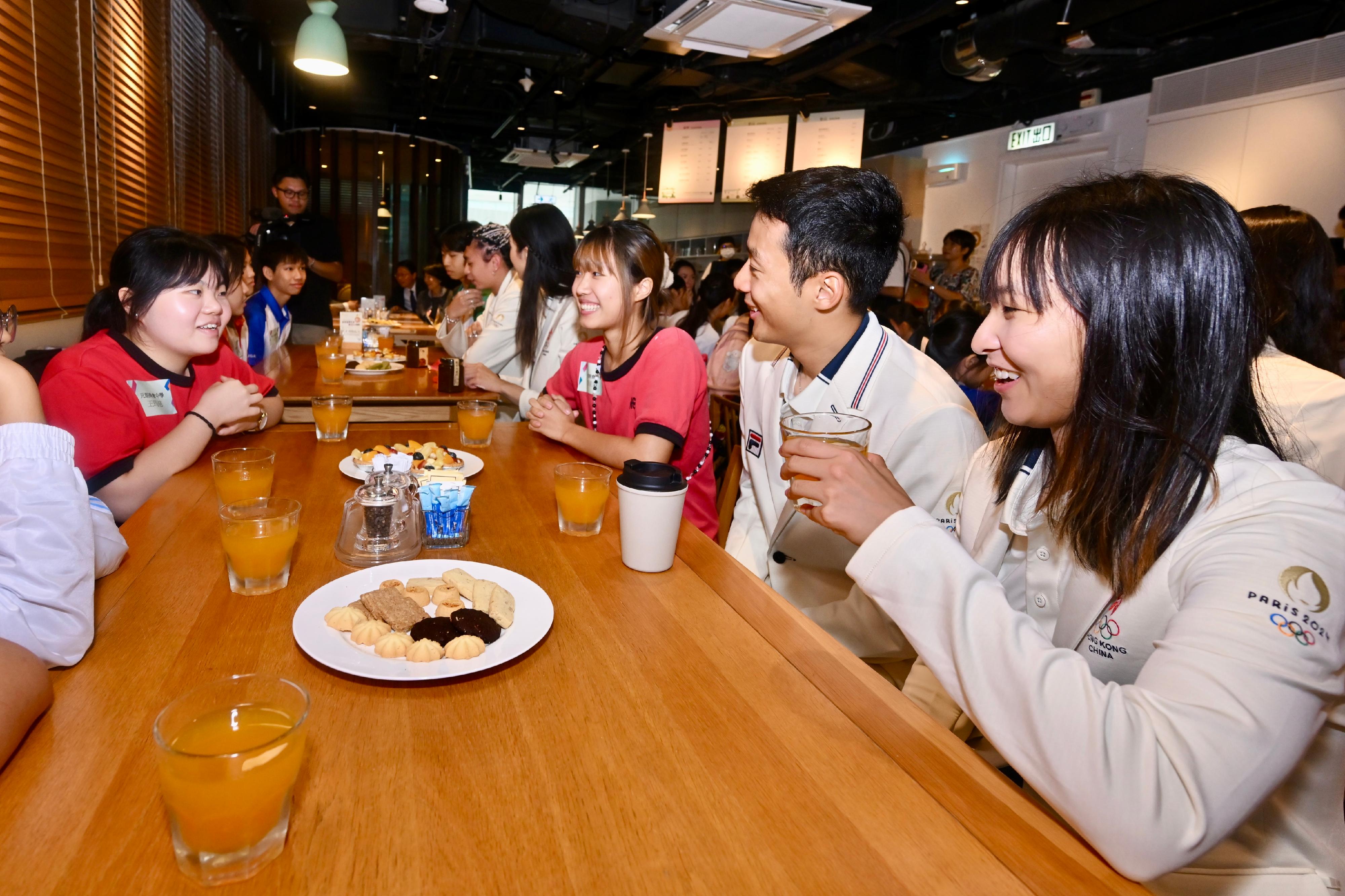 The Hong Kong Special Administrative Region Government and the Sports Federation & Olympic Committee of Hong Kong, China arranged a bus parade and Welcome Home Reception today (August 21) for the Hong Kong, China Delegation to the 2024 Paris Olympic Games. Photo shows the athletes interacting with students at iBakery upon their arrival at Tamar Park.