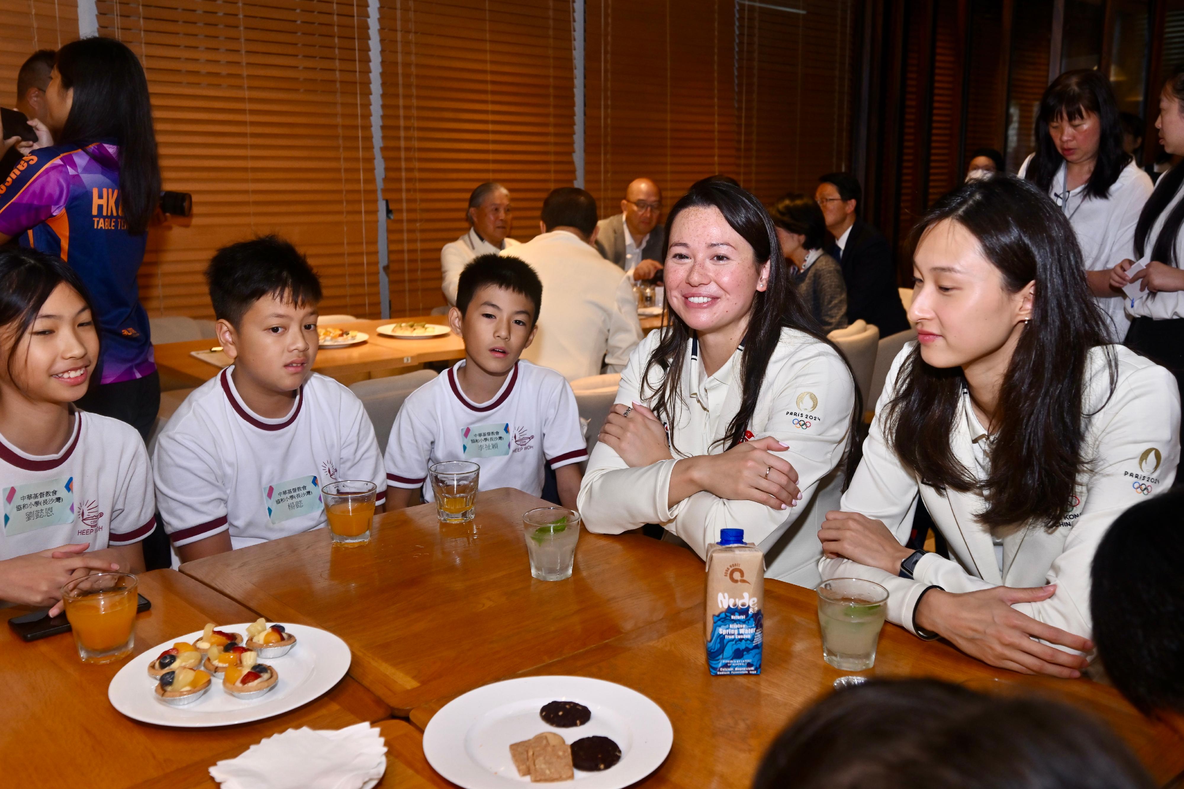 The Hong Kong Special Administrative Region Government and the Sports Federation & Olympic Committee of Hong Kong, China arranged a bus parade and Welcome Home Reception today (August 21) for the Hong Kong, China Delegation to the 2024 Paris Olympic Games. Photo shows the athletes interacting with students at iBakery upon their arrival at Tamar Park.