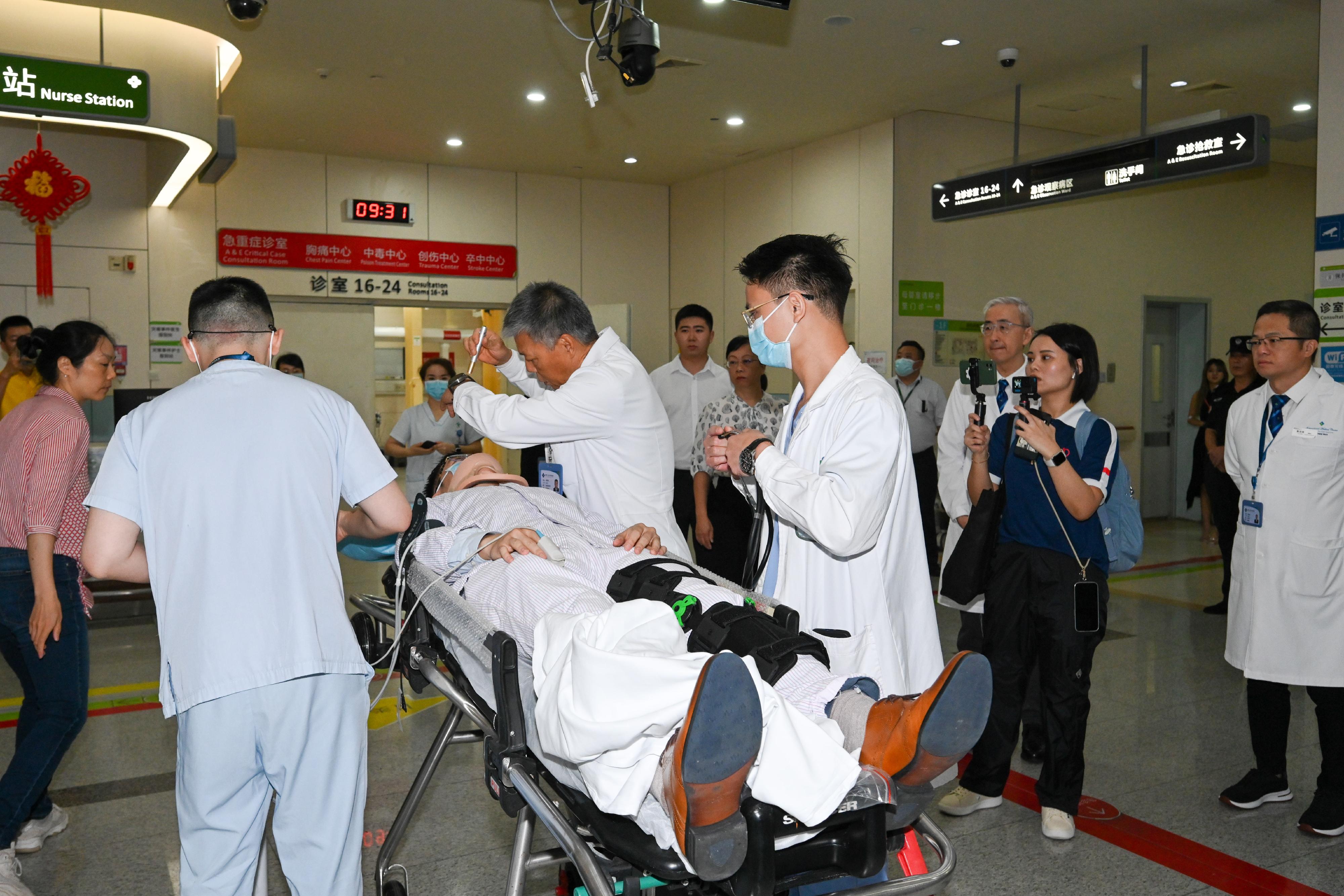 The Hong Kong Special Administrative Region Government conducted today (August 23) a drill for the Pilot Scheme for Direct Cross-boundary Ambulance Transfer in the Greater Bay Area in collaboration with the Guangdong Provincial Government and the Shenzhen Municipal Government. Photo shows healthcare personnel of the University of Hong Kong - Shenzhen Hospital simulating an examination of a patient before transfer.