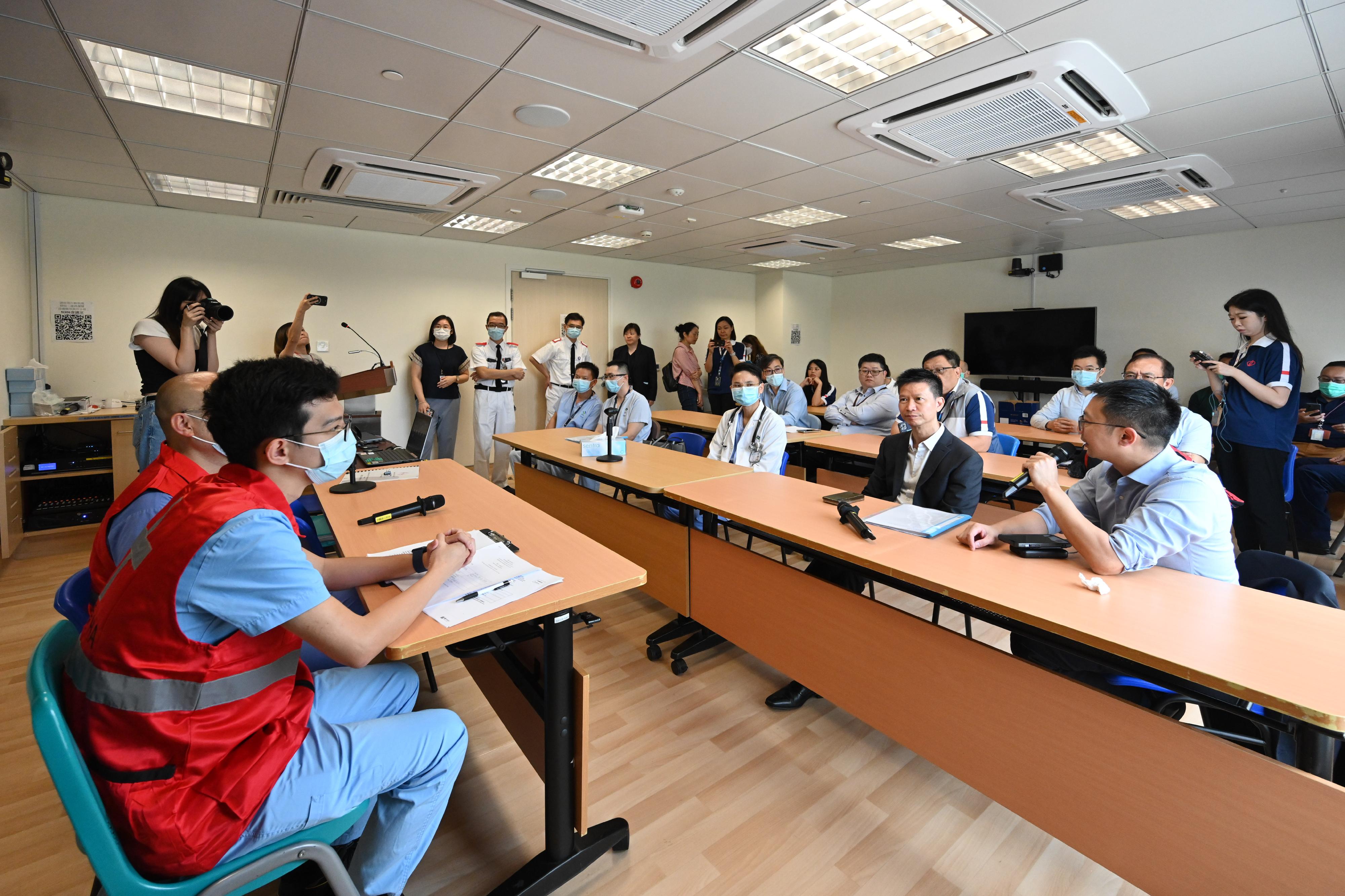 The Hong Kong Special Administrative Region (HKSAR) Government conducted today (August 23) a drill for the Pilot Scheme for Direct Cross-boundary Ambulance Transfer in the Greater Bay Area in collaboration with the Guangdong Provincial Government and the Shenzhen Municipal Government. Photo shows Deputy Secretary for Health Mr Sam Hui (front row, second right) and participating personnel having a preliminary review on the drill today with healthcare personnel of Tuen Mun Hospital.