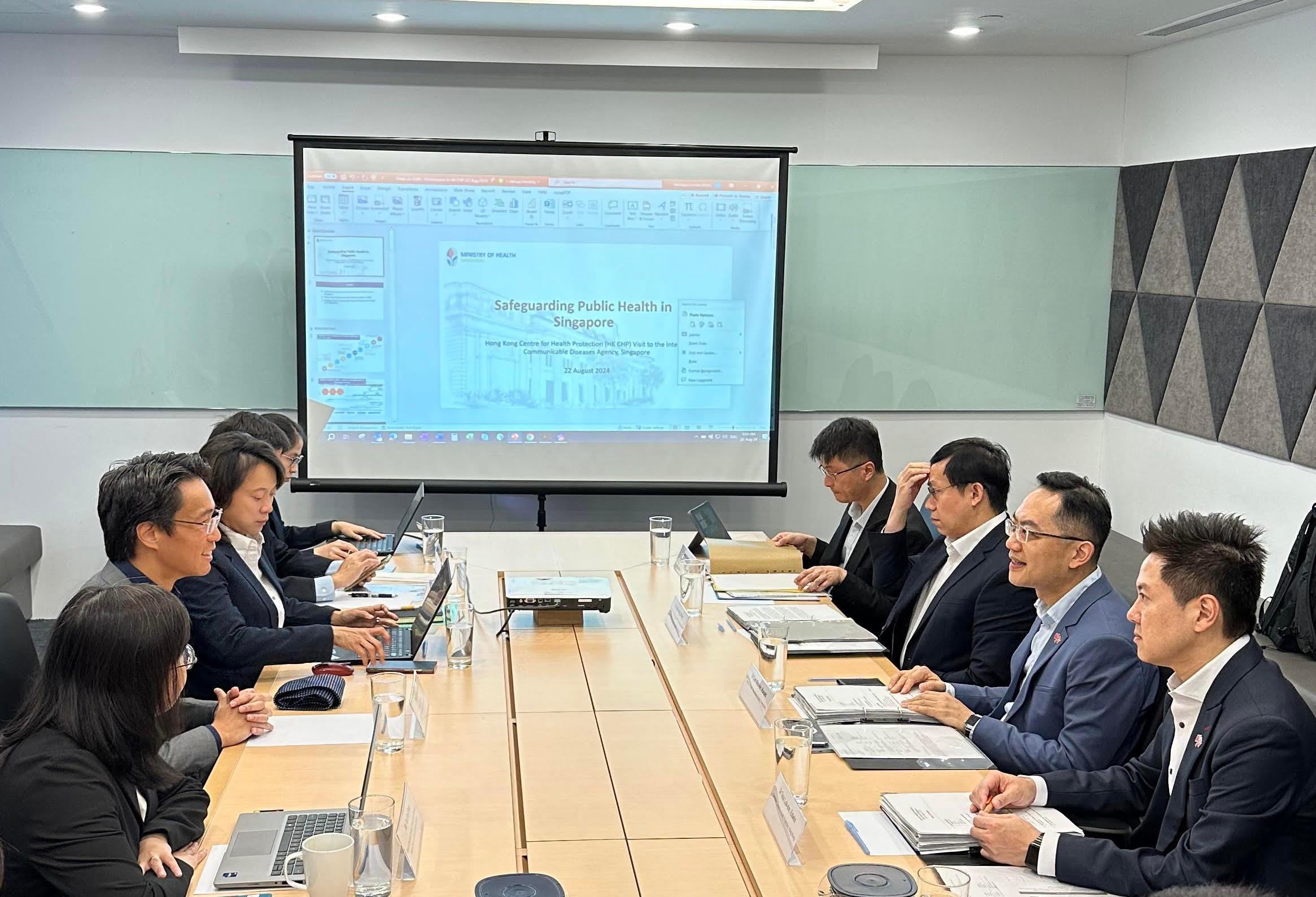 The Director of Health, Dr Ronald Lam, led a delegation from the Centre for Health Protection (CHP) of the Department of Health to Singapore and started a three-day visit on August 22. Photo shows Dr Lam (second right) and the Controller of the CHP, Dr Edwin Tsui (first right), visiting the interim Communicable Diseases Agency of Singapore to conduct work exchanges on the prevention and control of communicable diseases.