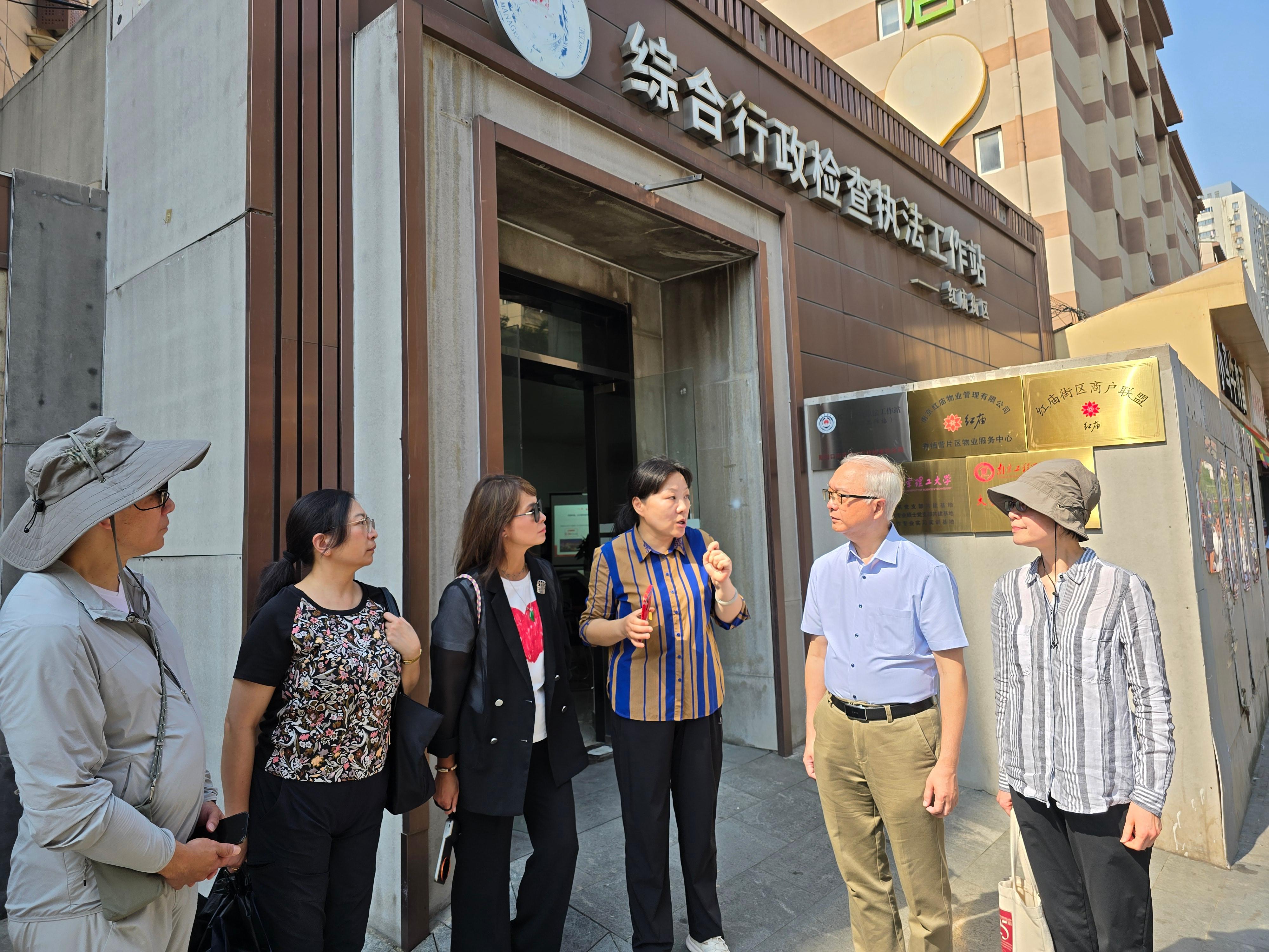 The Secretary for Environment and Ecology, Mr Tse Chin-wan, together with the Legislative Council Panel on Food Safety and Environmental Hygiene, visited Hongmiao area in Xuanwu District of Nanjing today (August 24). Photo shows Mr Tse (second right) and members of the delegation being briefed by a personnel on their work in urban management and law enforcement.
