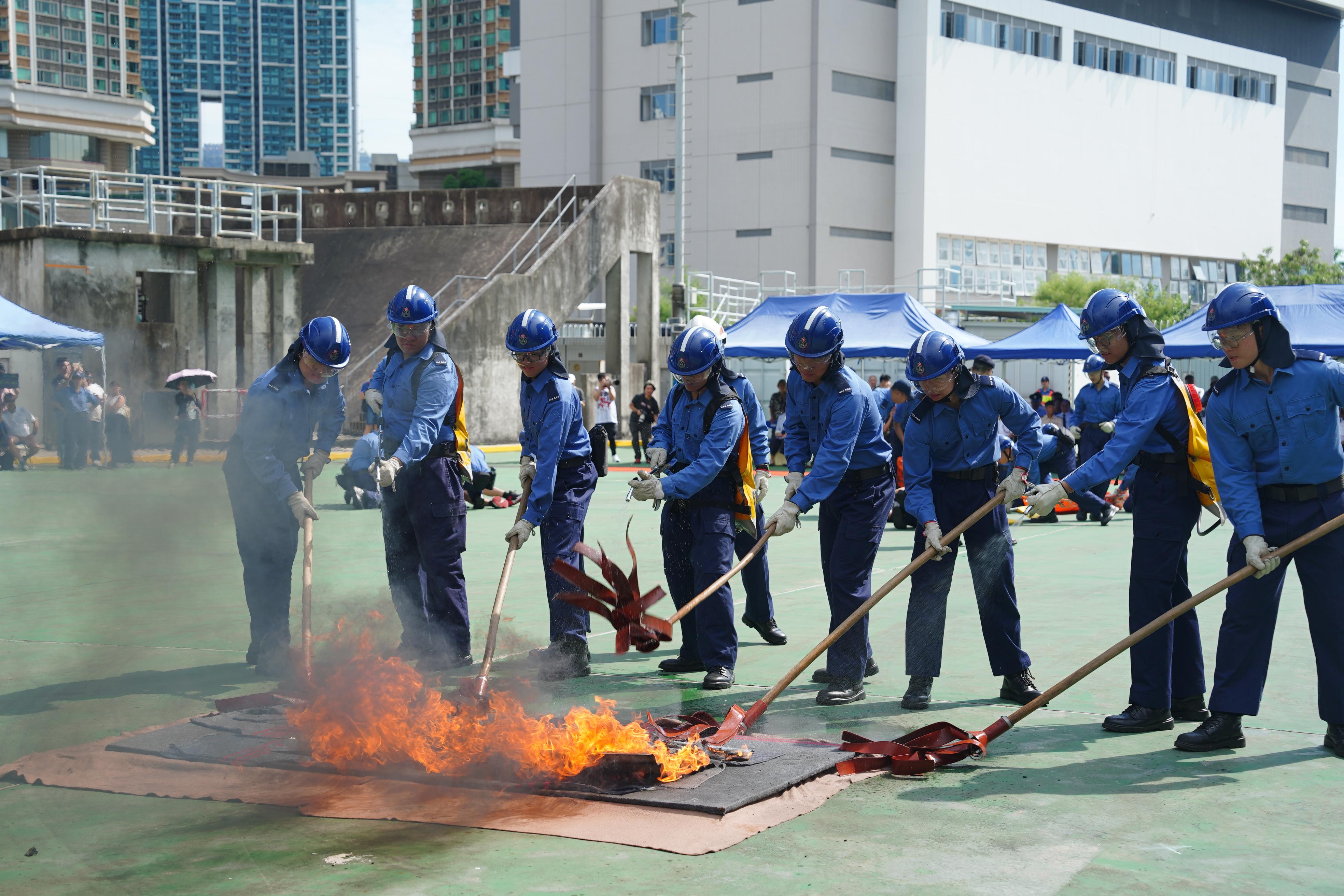 民众安全服务队（民安队）今日（八月二十五日）在民安队总部举行第八十八届新队员结业会操。图示队员示范扑灭山火。