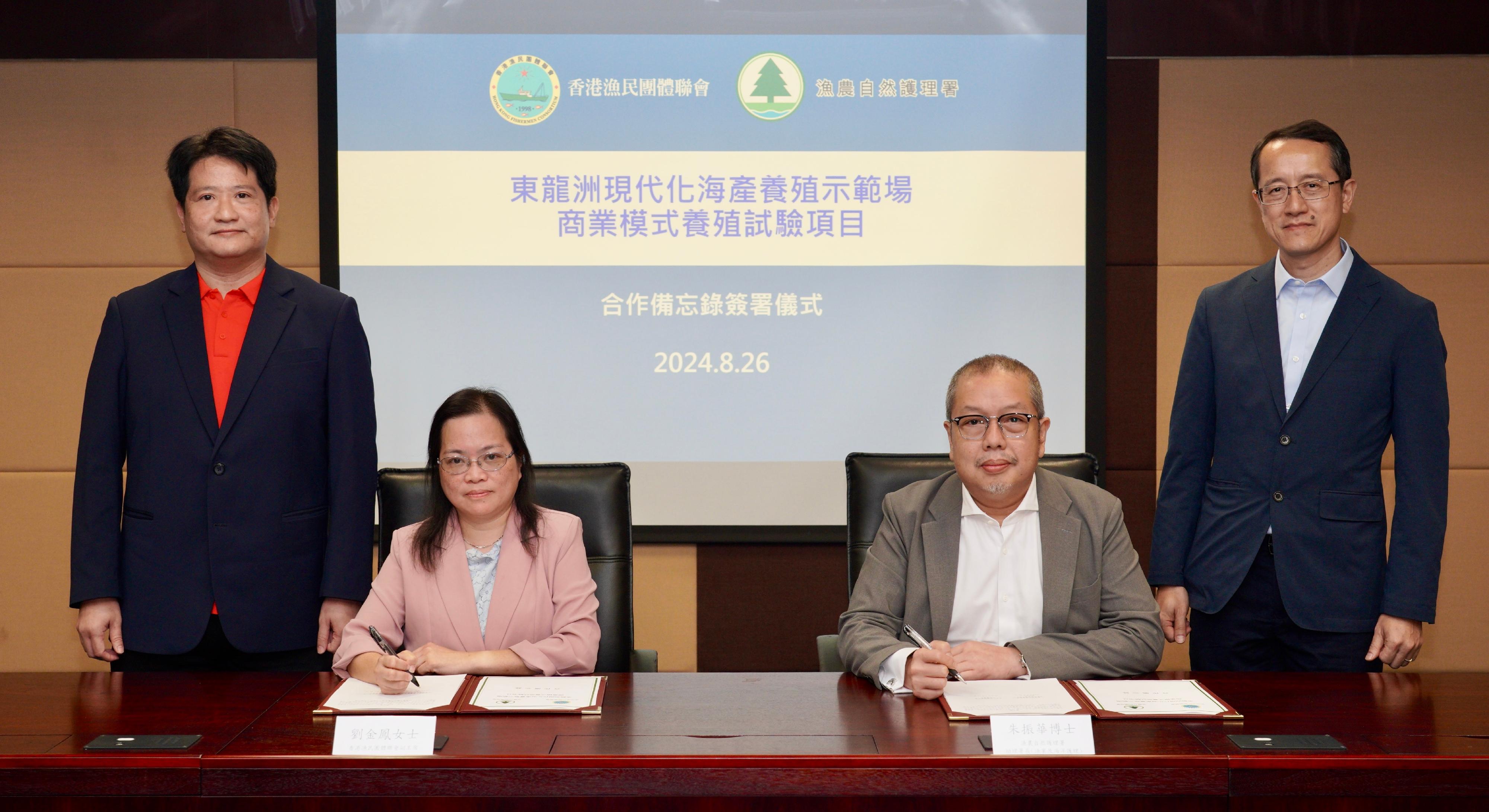 The Agriculture, Fisheries and Conservation Department (AFCD) signed a Memorandum of Understanding (MoU) today (August 26) with the Hong Kong Fishermen Consortium (HKFC) to launch a commercially operating aquaculture trial project at the modern mariculture demonstration farm at the Tung Lung Chau fish culture zone. Photo shows the Assistant Director (Fisheries and Marine Conservation) of the AFCD, Dr Jim Chu (second right), and the Vice Chairman of the HKFC, Ms Lau Kam-fung (second left), witnessed by the Deputy Director of Agriculture, Fisheries and Conservation, Mr Patrick Lai (first right), and the Executive Chairman of the HKFC, Mr Chan Pok-chi (first left), signing the MoU.
