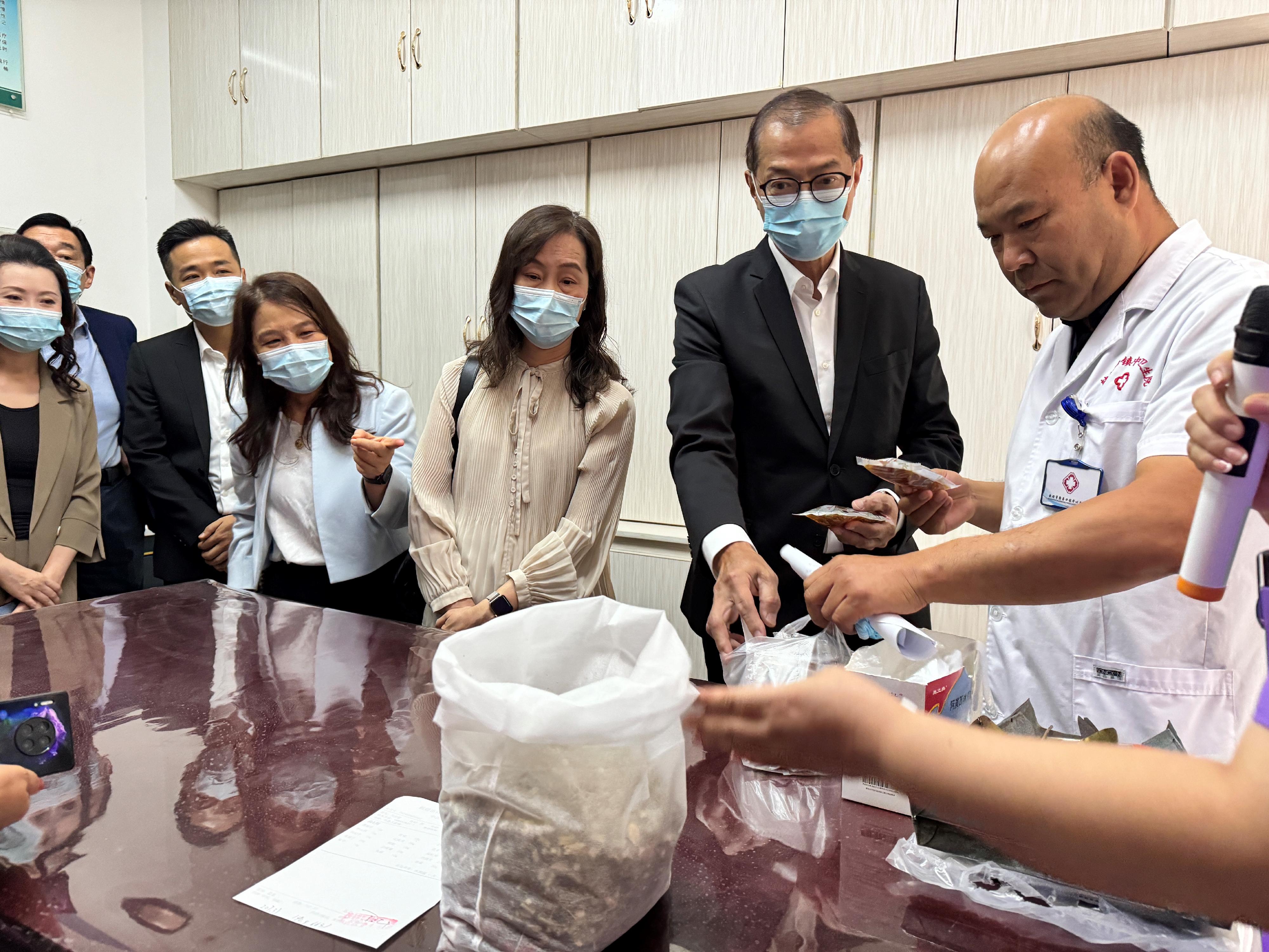 The Secretary for Health, Professor Lo Chung-mau, and his delegation visited the Zhuanqukou Community Health Center of Dunhuang City yesterday (August 28). Photo shows Professor Lo (second right) visiting the Chinese medicine pharmacy of the Center. The Secretary for Social Affairs and Culture of the Macao Special Administrative Region Government, Ms Ao Ieong U (third right), also attended the visit.
