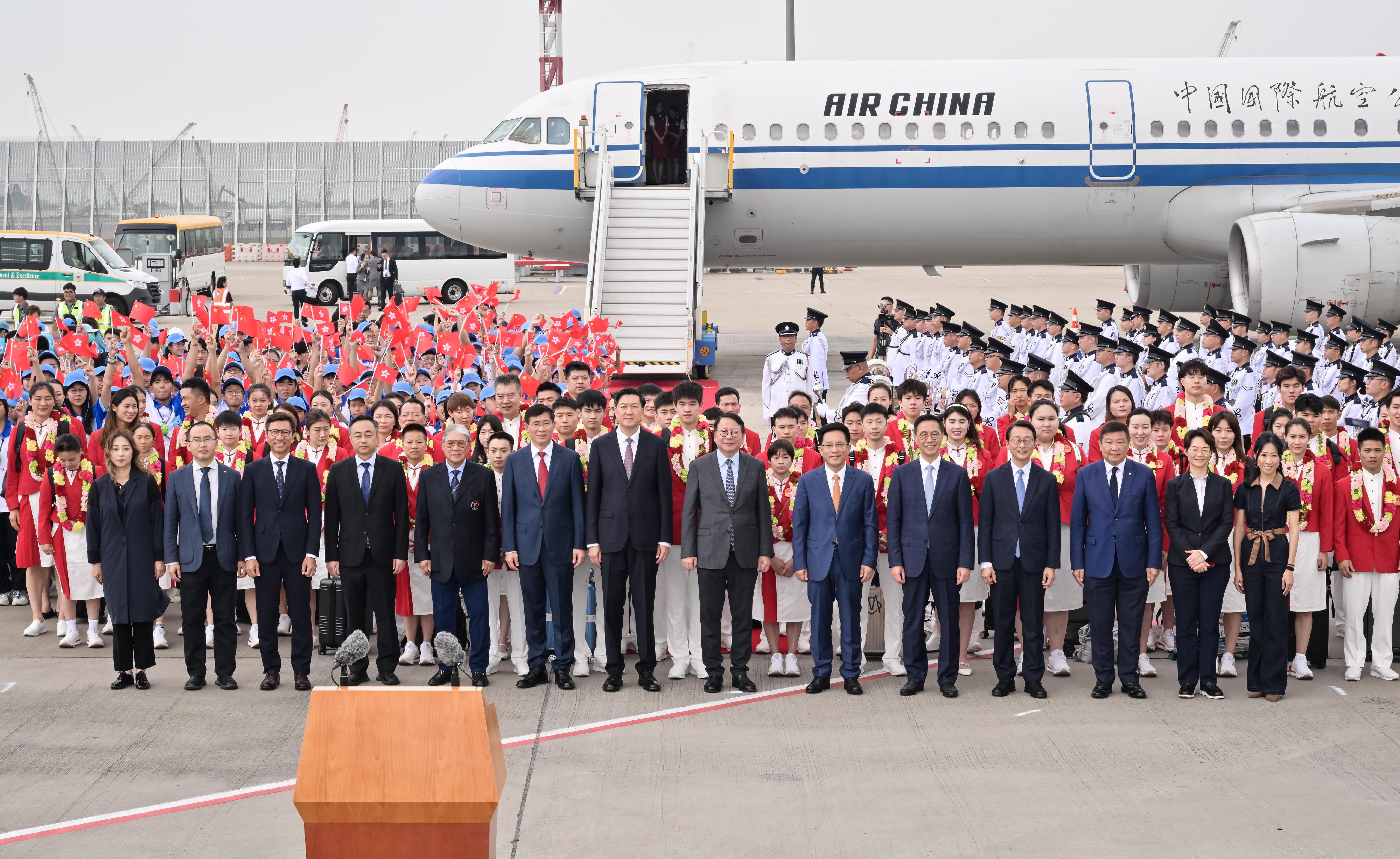 二○二四年巴黎奥运会内地奥运健儿代表团今日（八月二十九日）由团长、国家体育总局局长高志丹率领抵港访问三天。图示政务司司长陈国基（第一排右七）、高志丹（第一排左七）、中央人民政府驻香港特别行政区联络办公室秘书长王松苗（第一排右六）、中国香港体育协会暨奥林匹克委员会会长霍震霆（第一排左五）和文化体育及旅游局局长杨润雄（第一排右五）在香港国际机场举行的欢迎仪式与代表团和欢迎队伍合照。