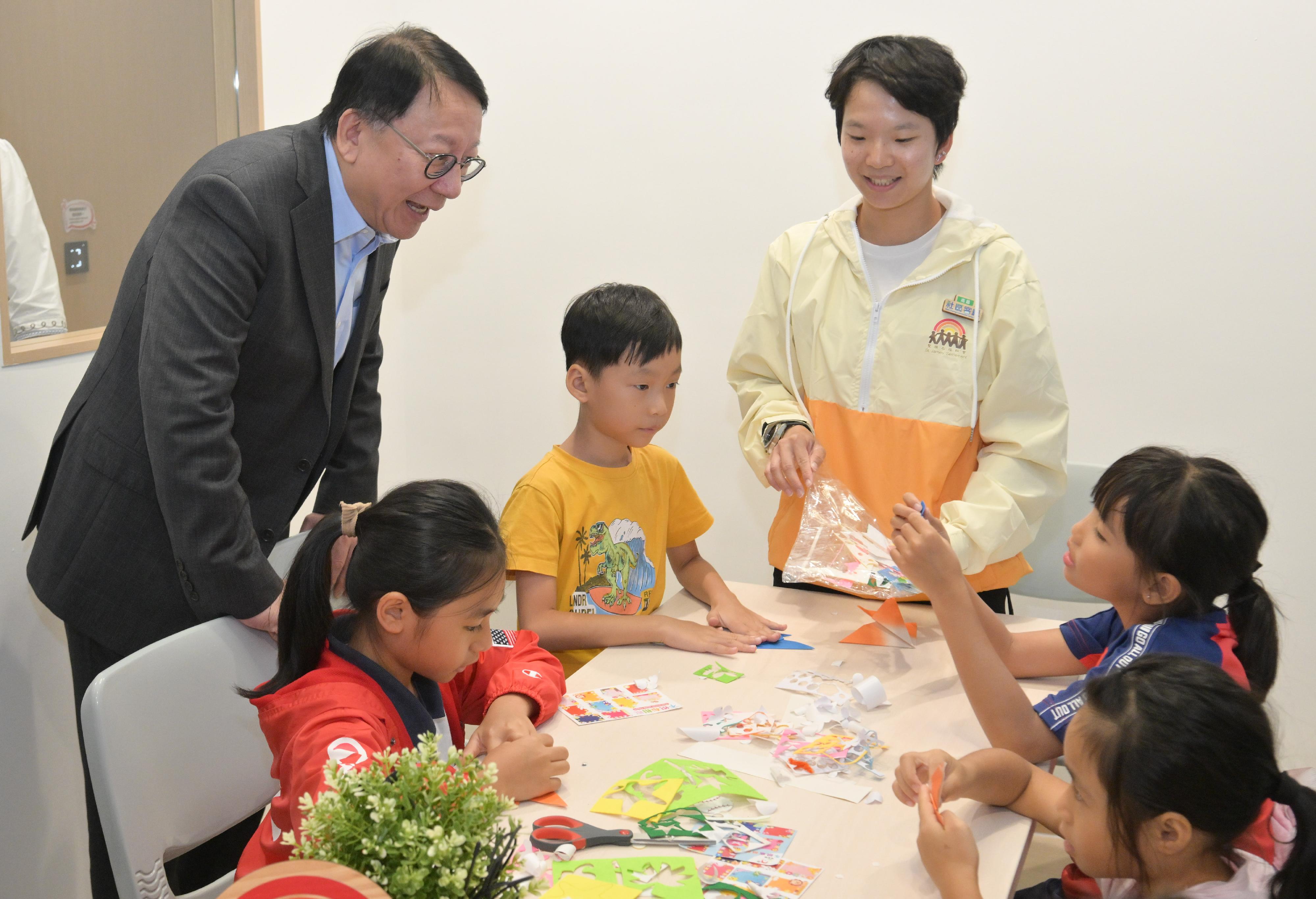 政务司司长陈国基今日（八月二十九日）主持南昌社区客厅开幕典礼。劳工及福利局局长孙玉菡亦一同主礼。图示陈国基（左一）参观学习室，与正在制作手工的学生交谈。