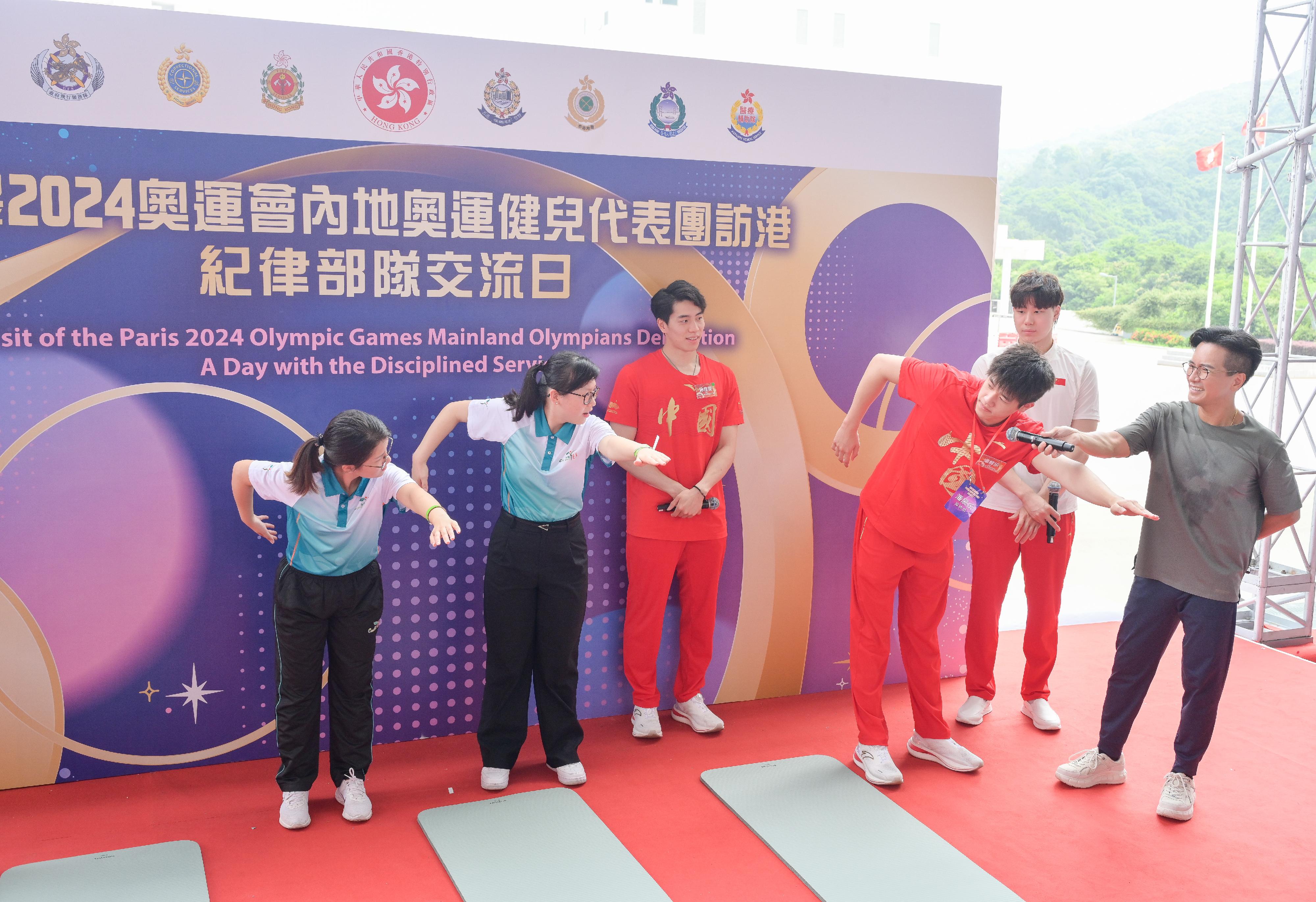 二○二四年巴黎奥运会内地奥运健儿代表团昨日（八月二十九日）起访问香港三日，当中29人包括22名运动员及三名教练今日（八月三十日）上午在消防及救护学院与纪律部队和辅助部队人员，及其辖下青少年制服团队队员交流会面，分享他们的得奖喜悦，并进行示范表演。图示内地游泳运动员潘展乐（右三）、覃海洋（右二）及孙佳俊（左三）示范游泳的技巧。