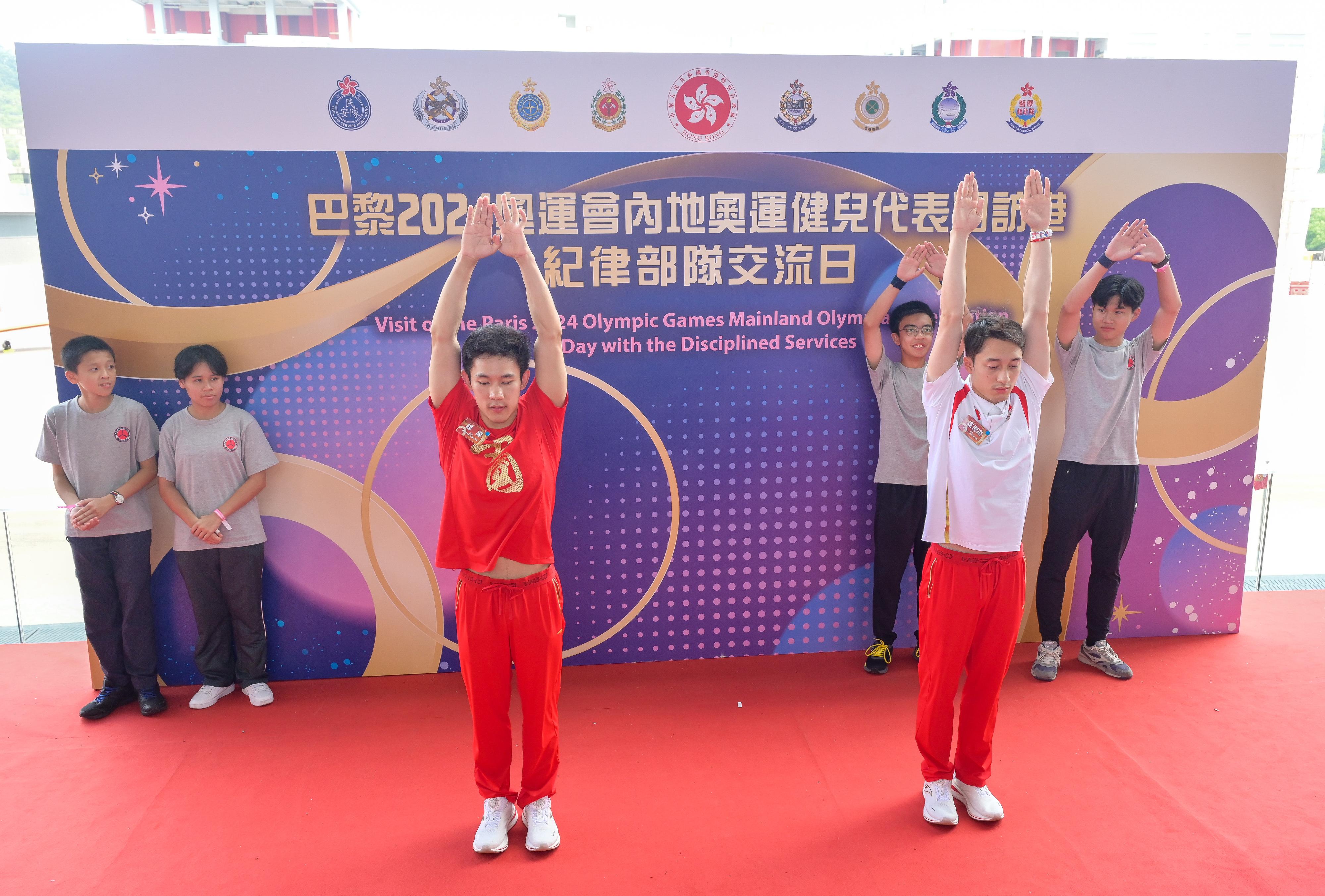 二○二四年巴黎奥运会内地奥运健儿代表团昨日（八月二十九日）起访问香港三日，当中29人包括22名运动员及三名教练今日（八月三十日）上午在消防及救护学院与纪律部队和辅助部队人员，及其辖下青少年制服团队队员交流会面，分享他们的得奖喜悦，并进行示范表演。图示内地跳水运动员练俊杰（前排右）及杨昊（前排左）示范跳水的技巧。