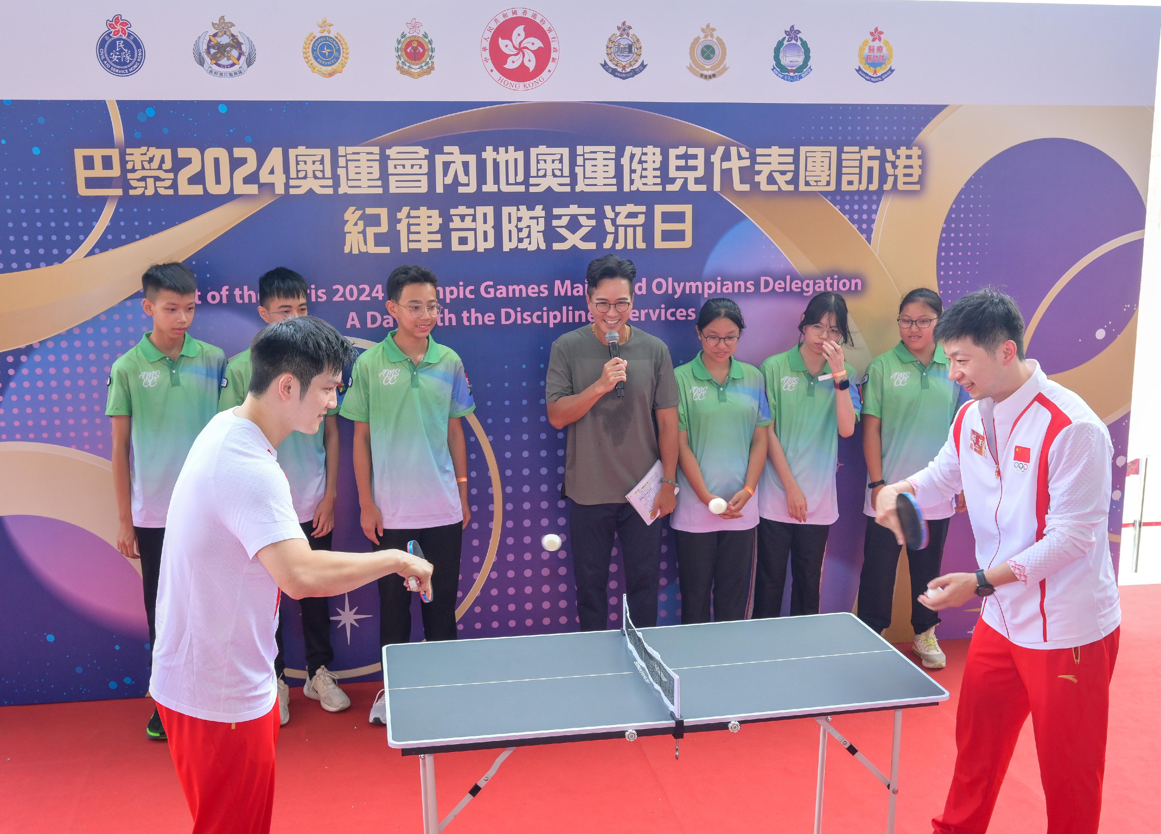 The delegation of the 2024 Paris Olympic Games Mainland Olympians arrived in Hong Kong yesterday (August 29) for a three-day visit. Twenty-nine people, including 22 athletes and three coaches, from the delegation met with members of the disciplined services and auxiliary services as well as their youth uniformed groups to share in the joy of the Olympians' achievements and give sports demonstrations at the Fire and Ambulance Services Academy this morning (August 30). Photo shows Mainland table tennis athletes Fan Zhendong (front row, first left) and Ma Long (front row, first right) demonstrating table tennis techniques.