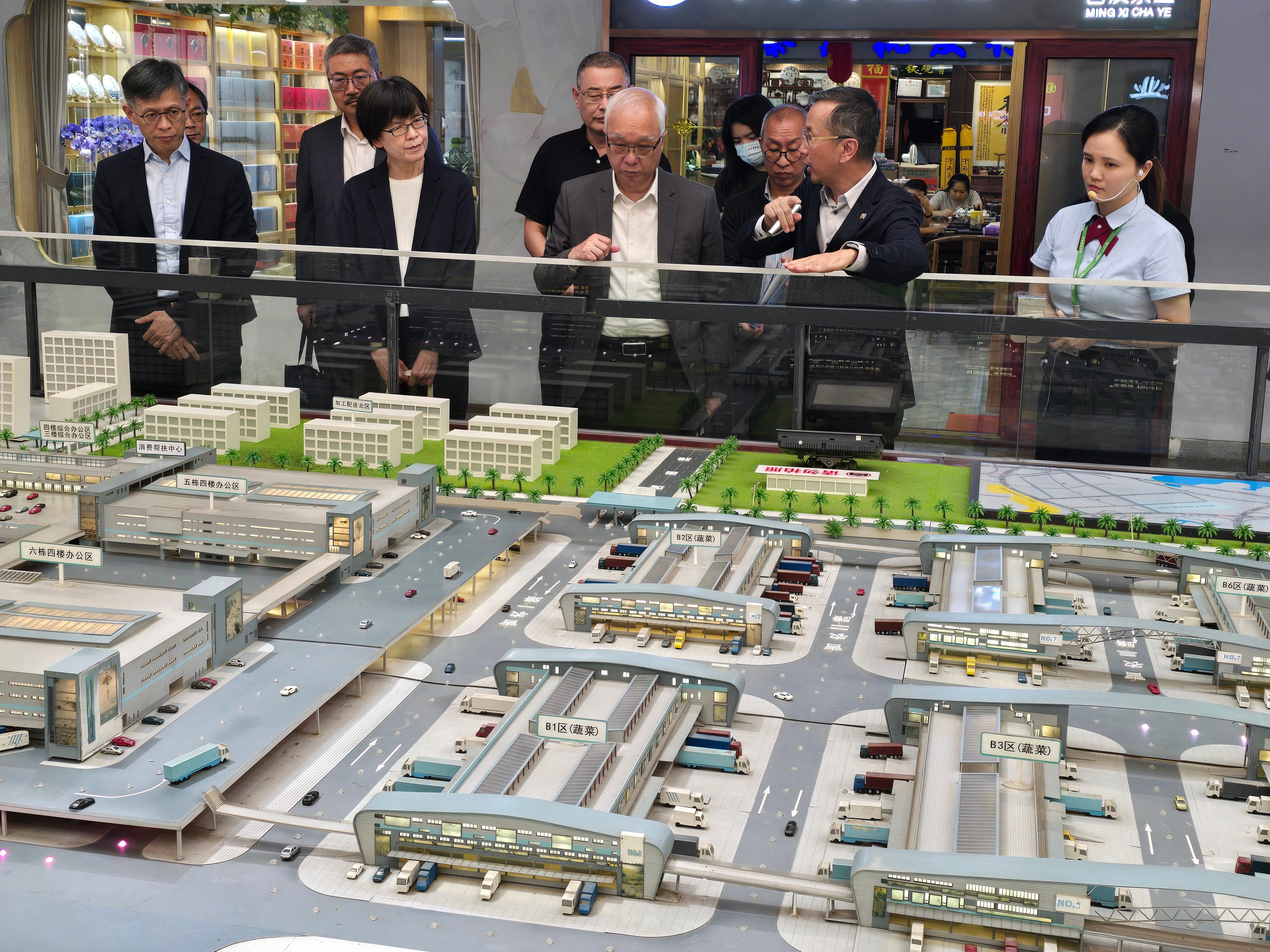 The Secretary for Environment and Ecology, Mr Tse Chin-wan, visited Shenzhen HiGreen Wholesale Market in Shenzhen today (September 3) to have an in-depth exchange on the latest developments of modern logistics and wholesale and trading of agricultural products. Photo shows Mr Tse (front row, centre); the Permanent Secretary for Environment and Ecology (Food), Miss Vivian Lau (front row, second left); and the Director of Agriculture, Fisheries and Conservation, Mr Mickey Lai (front row, first left), being briefed by the staff of the Wholesale Market on its planning, layout and major facilities.