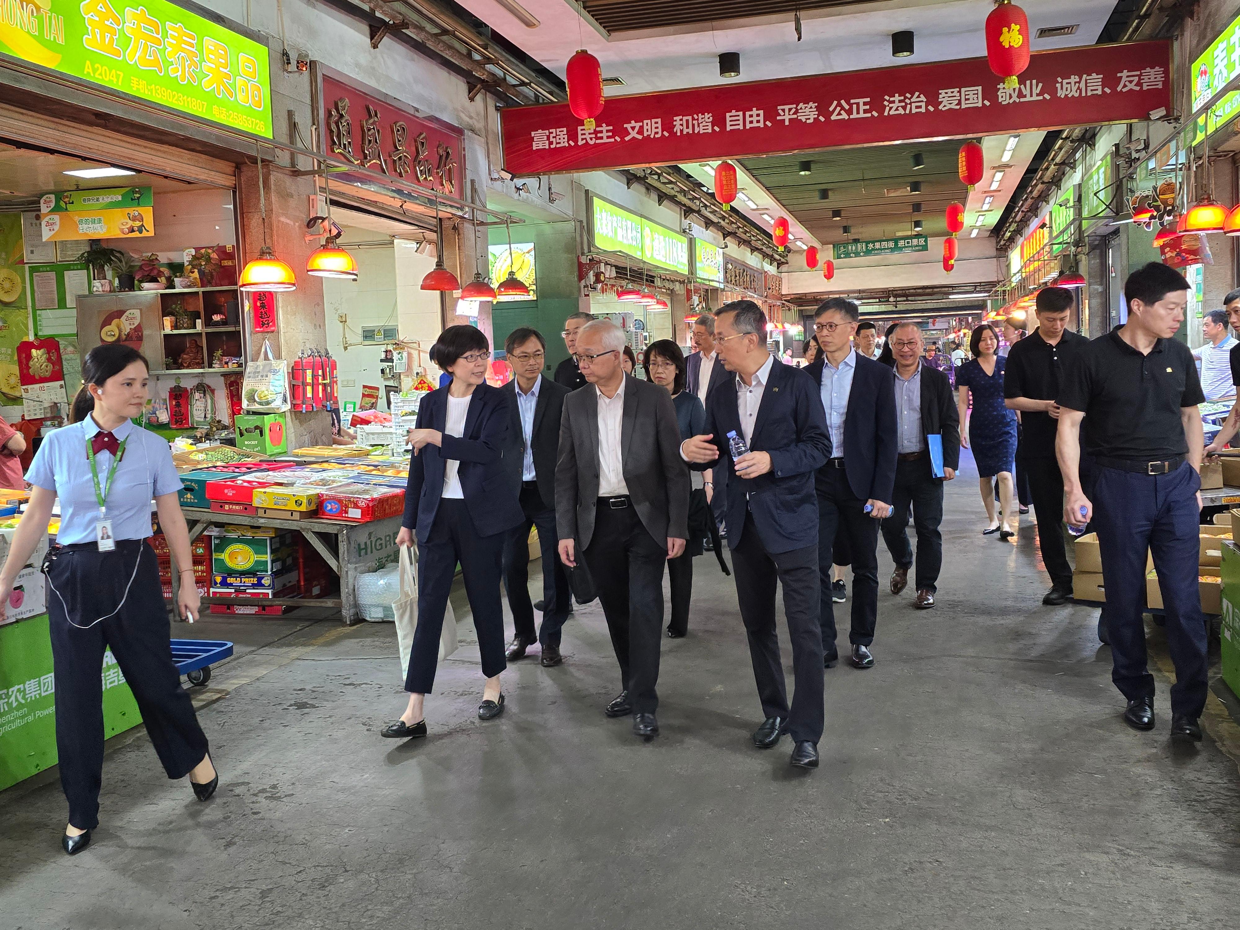 The Secretary for Environment and Ecology, Mr Tse Chin-wan, visited Shenzhen HiGreen Wholesale Market in Shenzhen today (September 3) to have an in-depth exchange on the latest developments of modern logistics and wholesale and trading of agricultural products. Photo shows Mr Tse (first row, centre); the Permanent Secretary for Environment and Ecology (Food), Miss Vivian Lau (first row, first left); and the Director of Agriculture, Fisheries and Conservation, Mr Mickey Lai (second row, first right), visiting the fruits and vegetables trading area of the Wholesale Market to learn about the clearing and logistics arrangements. 