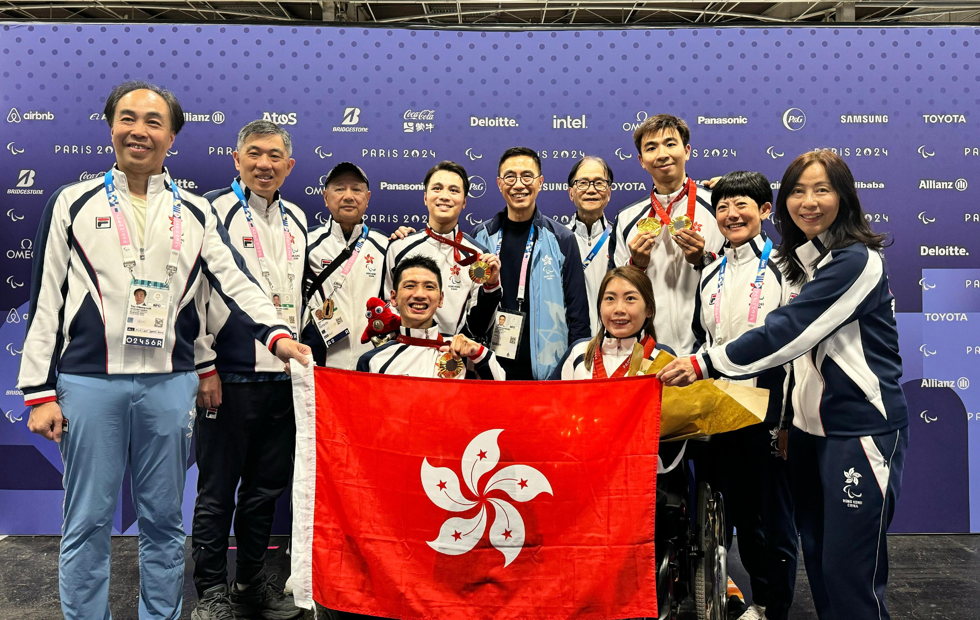 The Secretary for Culture, Sports and Tourism, Mr Kevin Yeung (back row, centre), yesterday (September 5, Paris time) went to the competition venue of the 2024 Paris Paralympic Games. He congratulated the Hong Kong athletes, Ho Yuen-kei, (front row, right) and Tse Tak-wah (front row, left), who won a gold medal in the Boccia Mixed Pairs BC3 event at the 2024 Paris Paralympics Games, as well as their coaches and support team.