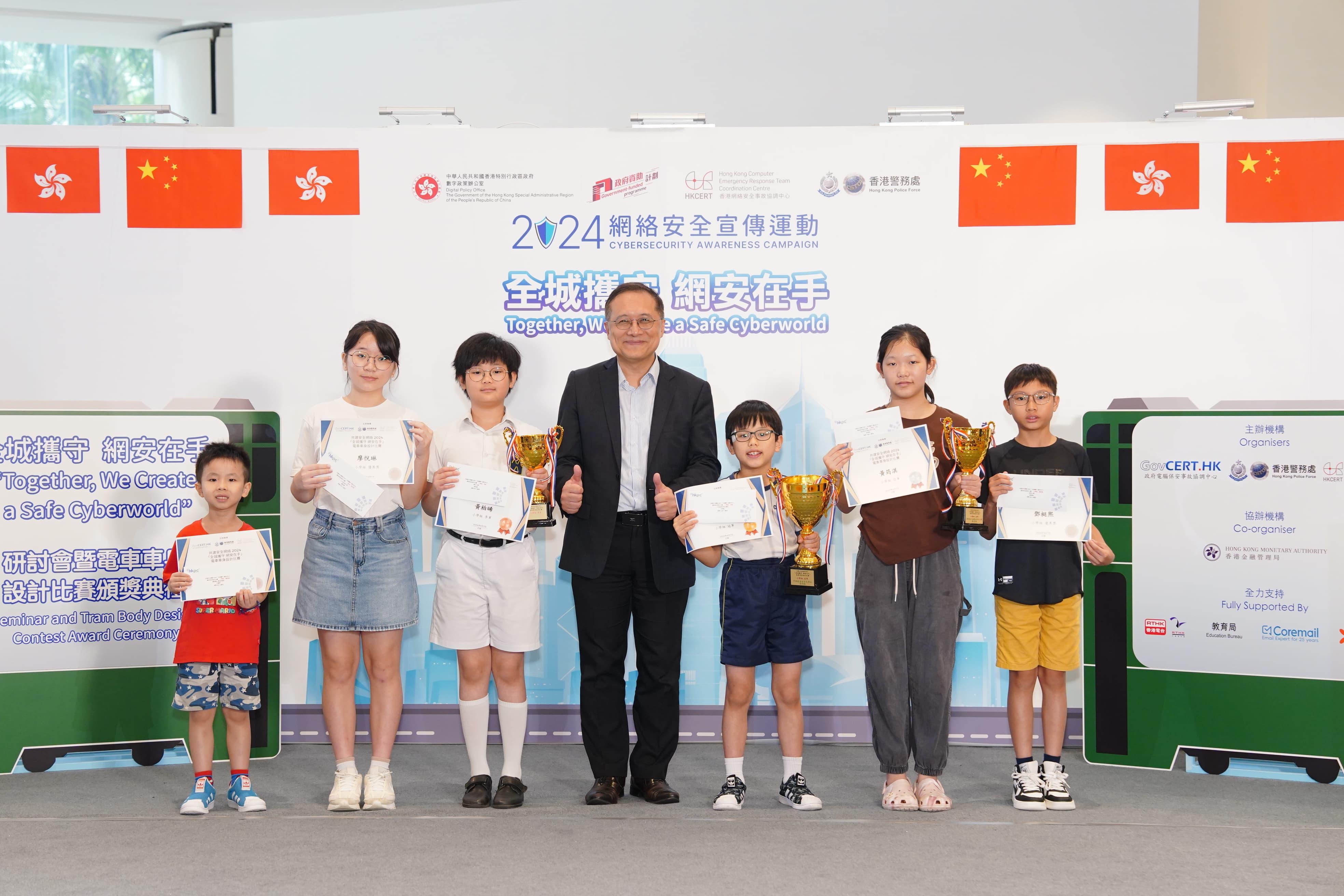 The Assistant Commissioner (Project Governance and Cybersecurity) of the Digital Policy Office, Mr Kingsley Wong (centre), presented awards to winners of the "Together, We Create a Safe Cyberworld" Tram Body Design Contest (Primary School Category) today (September 7).