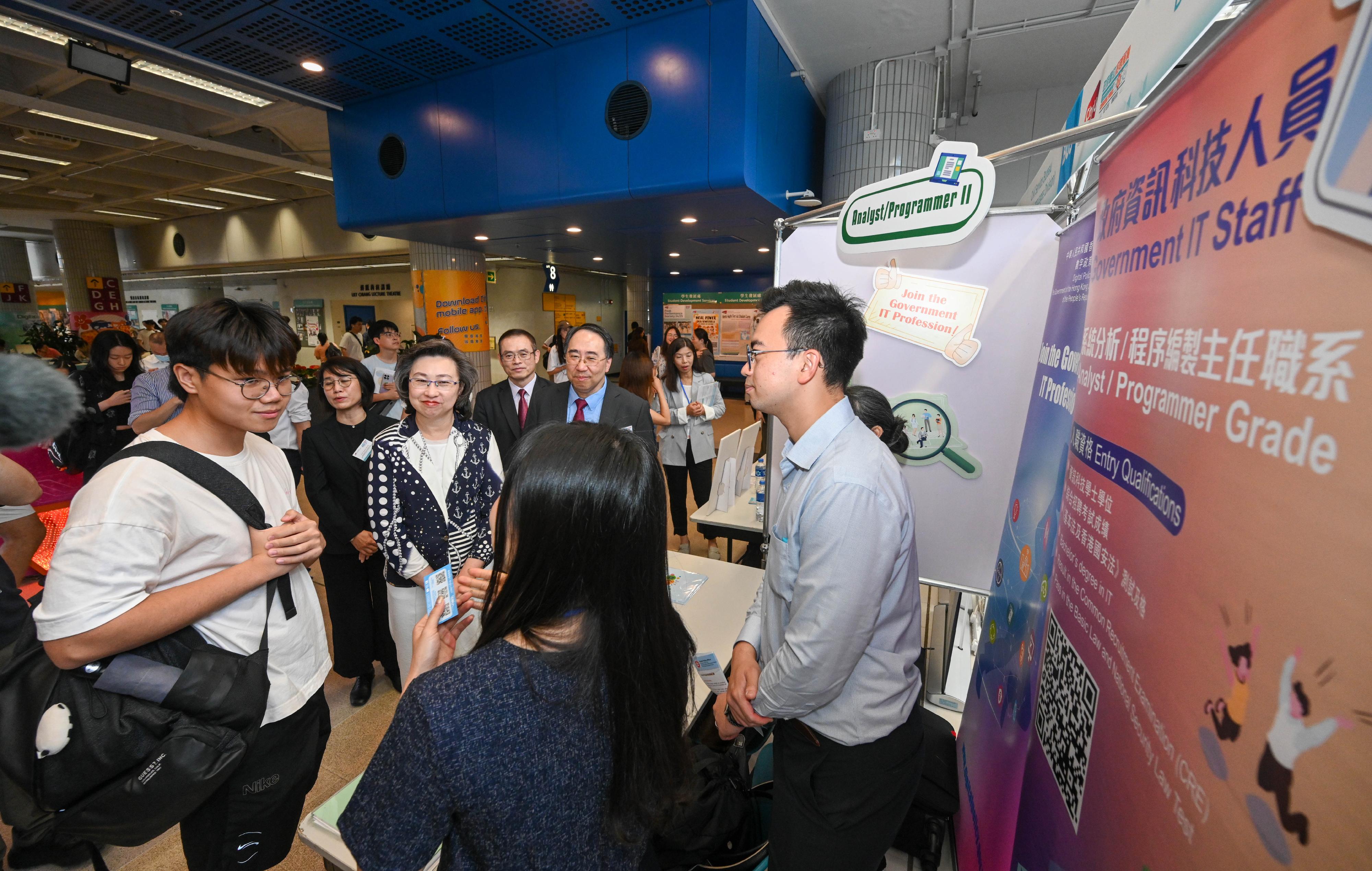 The Secretary for the Civil Service, Mrs Ingrid Yeung, today (September 11) officiated at the opening ceremony of the Government Career Fair at City University of Hong Kong (CityU) to launch a series of Government Career Fairs to be held at local universities and toured the exhibition booths of various government departments. Picture shows Mrs Yeung (third right) listening to staff briefing a student on department information at the Digital Policy Office booth. Looking on is the Provost and Deputy President of CityU, Professor Lee Chun-sing (second right).