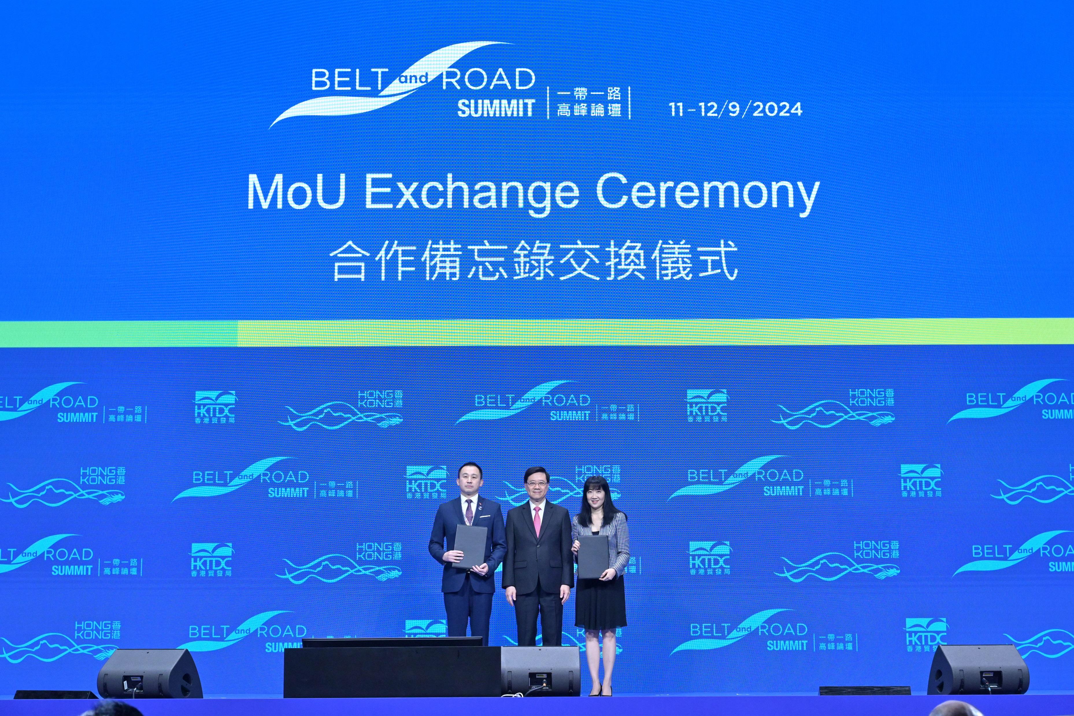 The Chief Executive, Mr John Lee, attended the Ninth Belt and Road Summit today (September 11). Photo shows Mr Lee (centre) witnessing the Executive Director of the Hong Kong Trade Development Council, Ms Margaret Fong (right), exchanging the Memorandum of Understanding with a representative from the Ministry of Commerce of Cambodia.