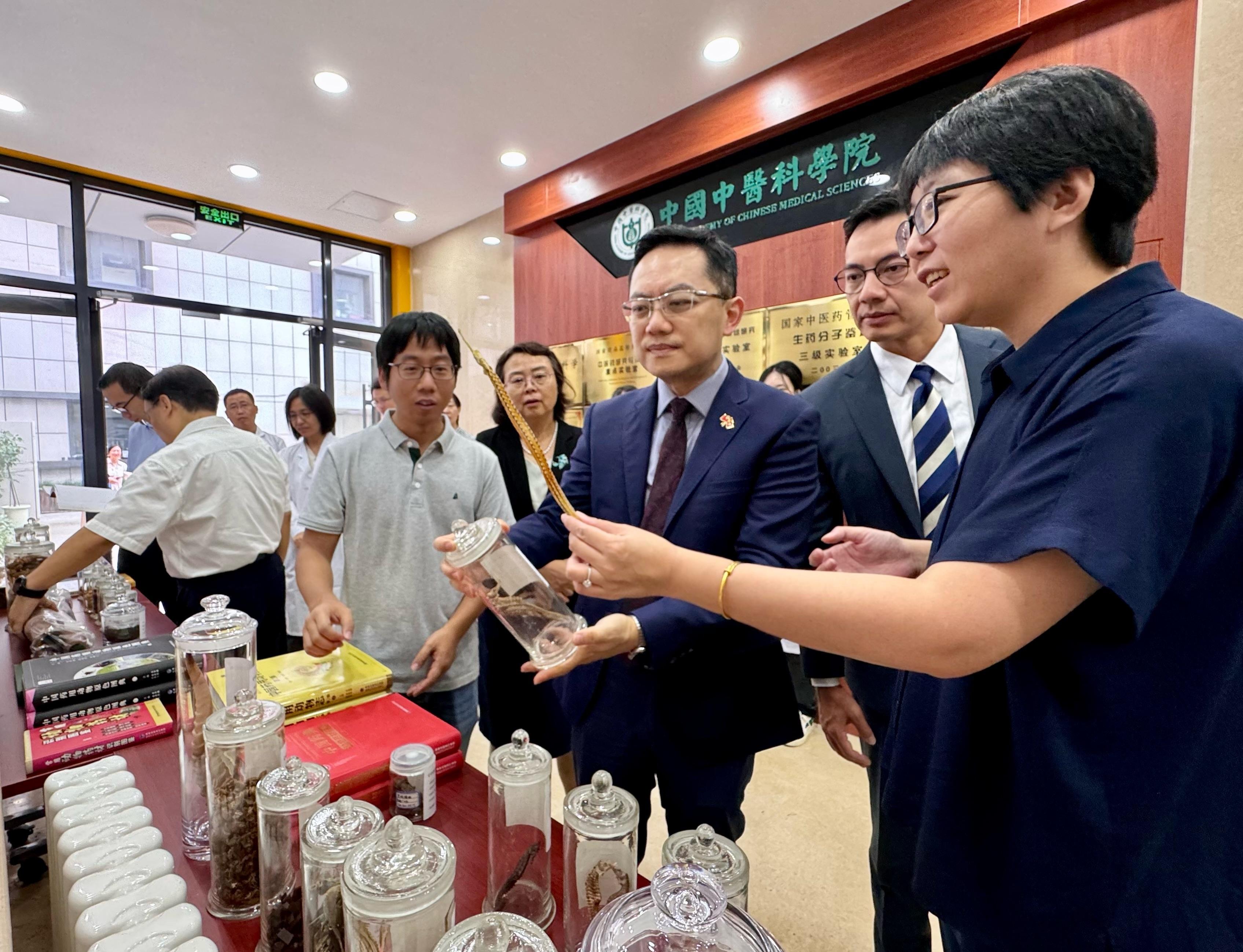 The Director of Health, Dr Ronald Lam, today (September 11) witnessed in Beijing the Department of Health and the Experimental Research Center of the China Academy of Chinese Medical Sciences (CACMS), which is a subsidiary organisation under the National Administration of Traditional Chinese Medicine, signing a Co-operation Arrangement on Research for Quality Testing and Standards of Chinese Medicines that covers a period of five years. Photo shows Dr Lam (third right) and the Assistant Director of Health (Chinese Medicine), Dr Edmund Fong (second right), visiting the CACMS to learn about the latest development of Chinese medicines testing and research work in the Mainland.