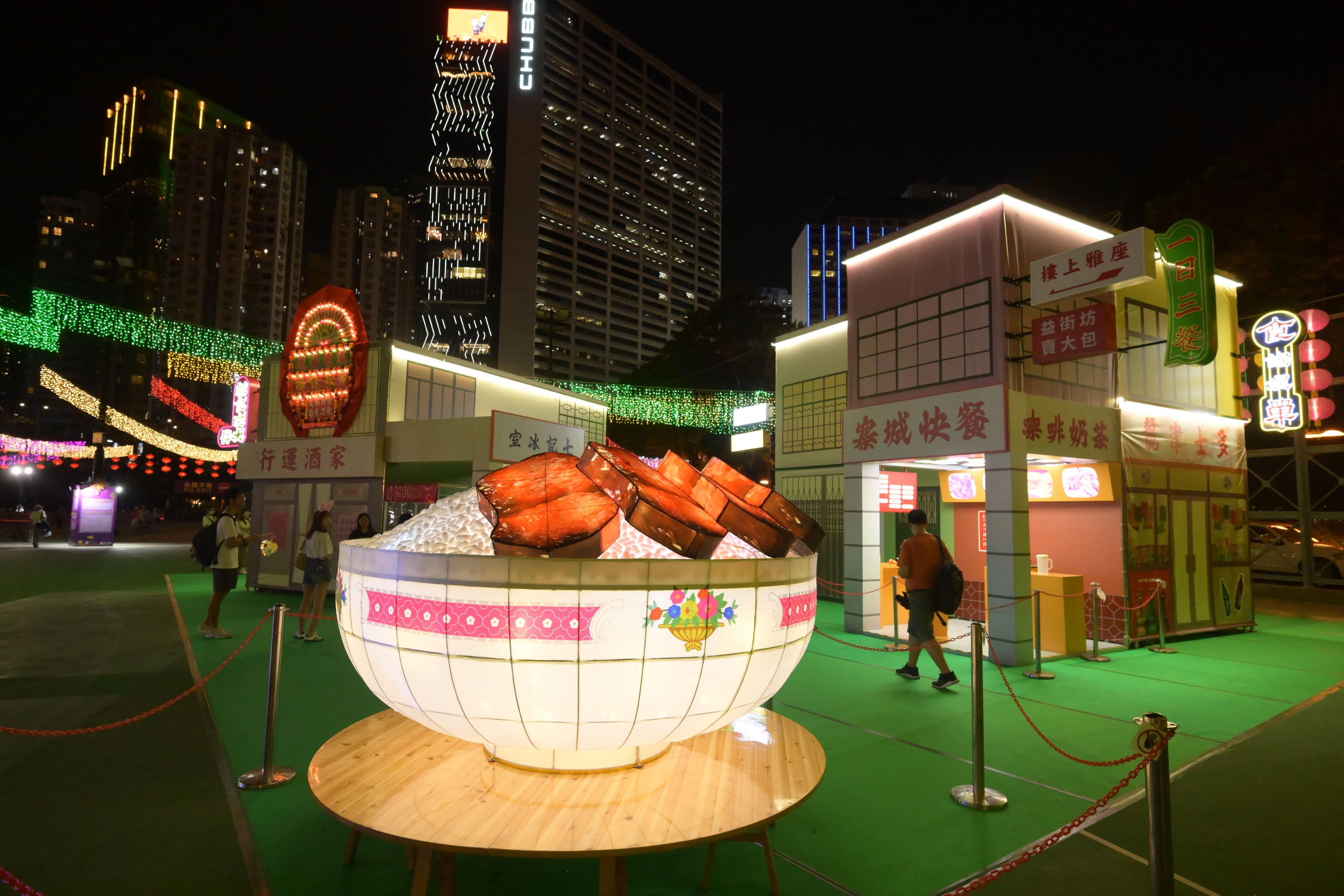 To celebrate National Day in advance, the Mid-Autumn Lantern Carnivals 2024 presented by the Leisure and Cultural Services Department are taking place at Victoria Park and Tsing Yi Park from today (September 12) until September 18. Photo shows the "Eating" lantern with local street-food stalls and celebrated delicacies as a backdrop, now on display at Victoria Park.