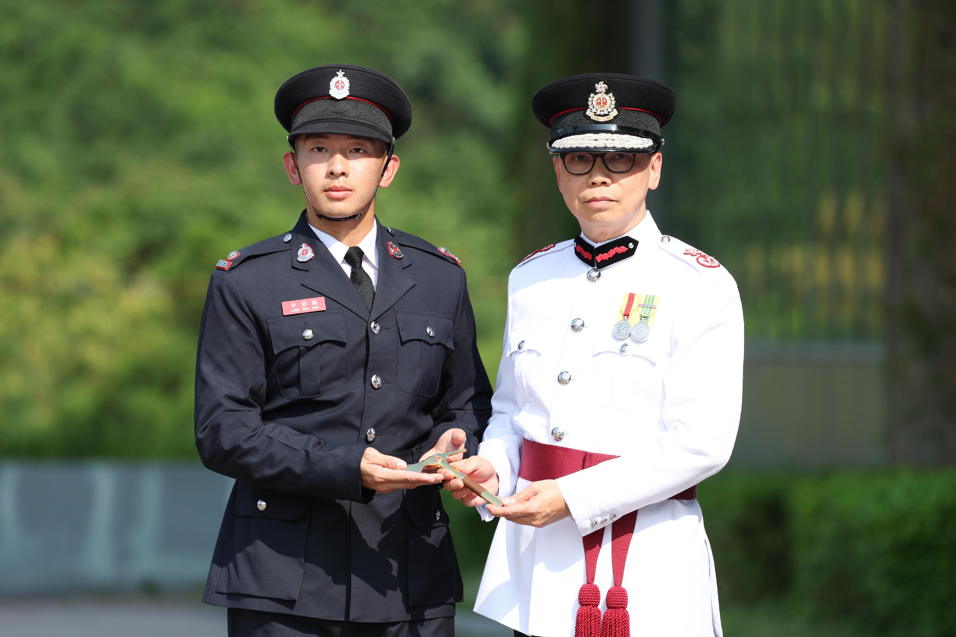 The Deputy Director of Fire Services (Operations), Mr Angus Wong, reviewed the Fire Services passing-out parade at the Fire and Ambulance Services Academy today (September 13). Photo shows Mr Wong (right) presenting the Best Recruit Station Officer award to a graduate.