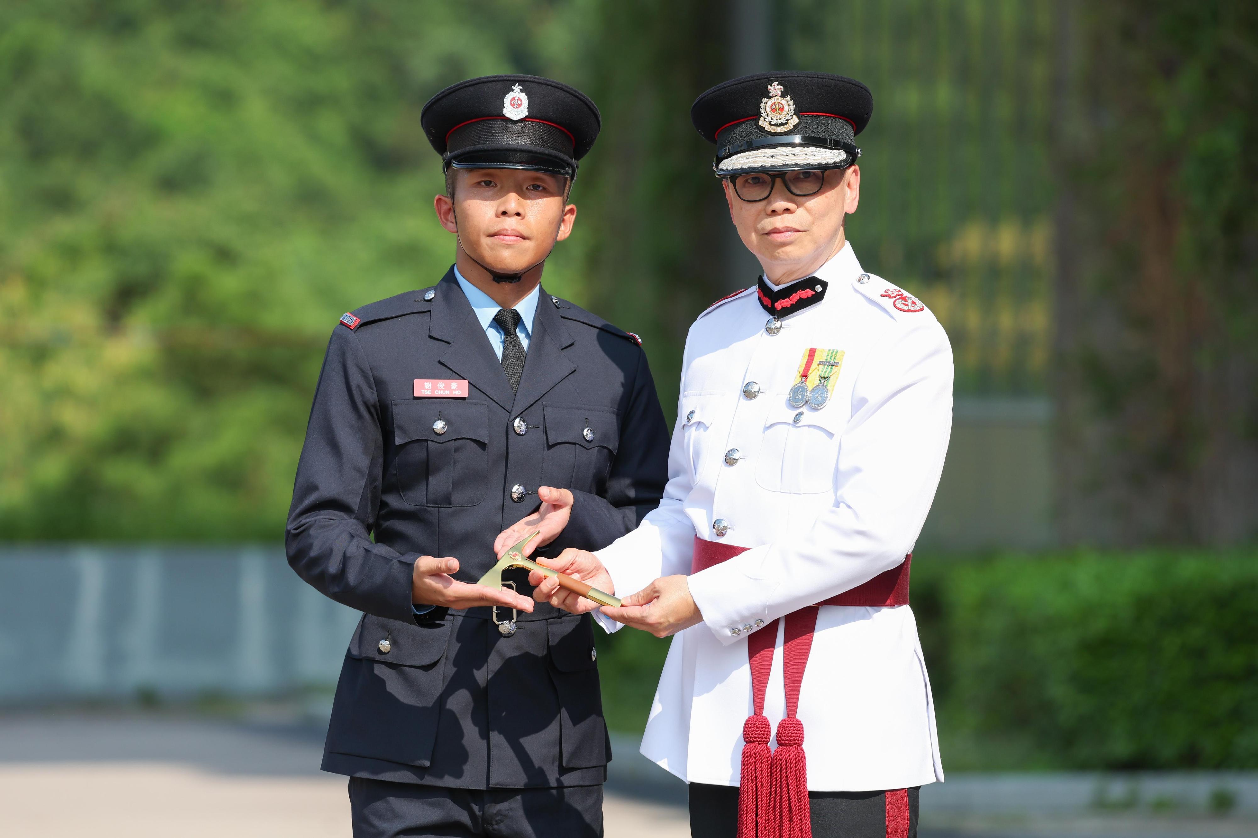 The Deputy Director of Fire Services (Operations), Mr Angus Wong, reviewed the Fire Services passing-out parade at the Fire and Ambulance Services Academy today (September 13). Photo shows Mr Wong (right) presenting the Best Recruit Fireman award to a graduate.