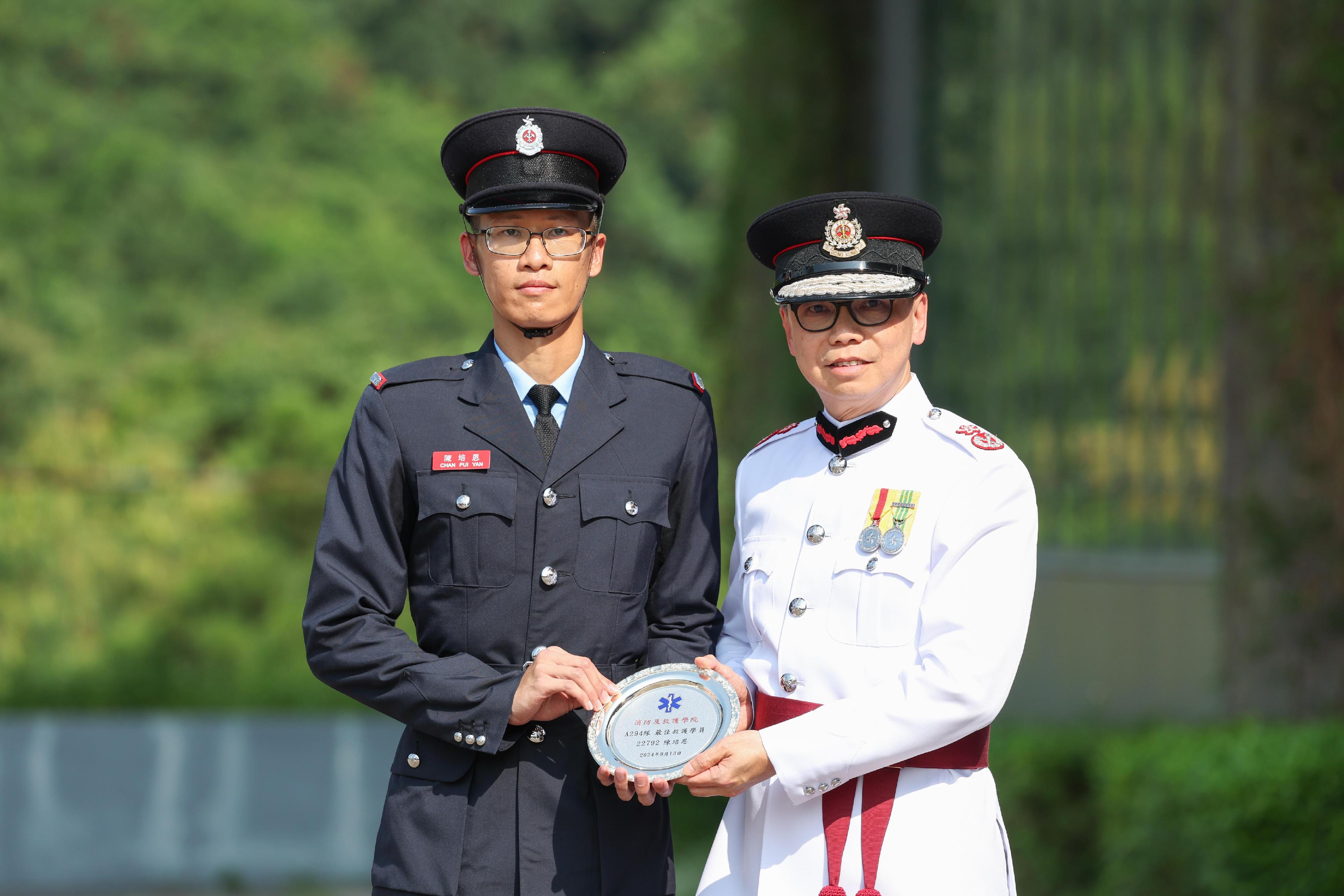 The Deputy Director of Fire Services (Operations), Mr Angus Wong, reviewed the Fire Services passing-out parade at the Fire and Ambulance Services Academy today (September 13). Photo shows Mr Wong (right) presenting the Best Recruit Ambulanceman award to a graduate.