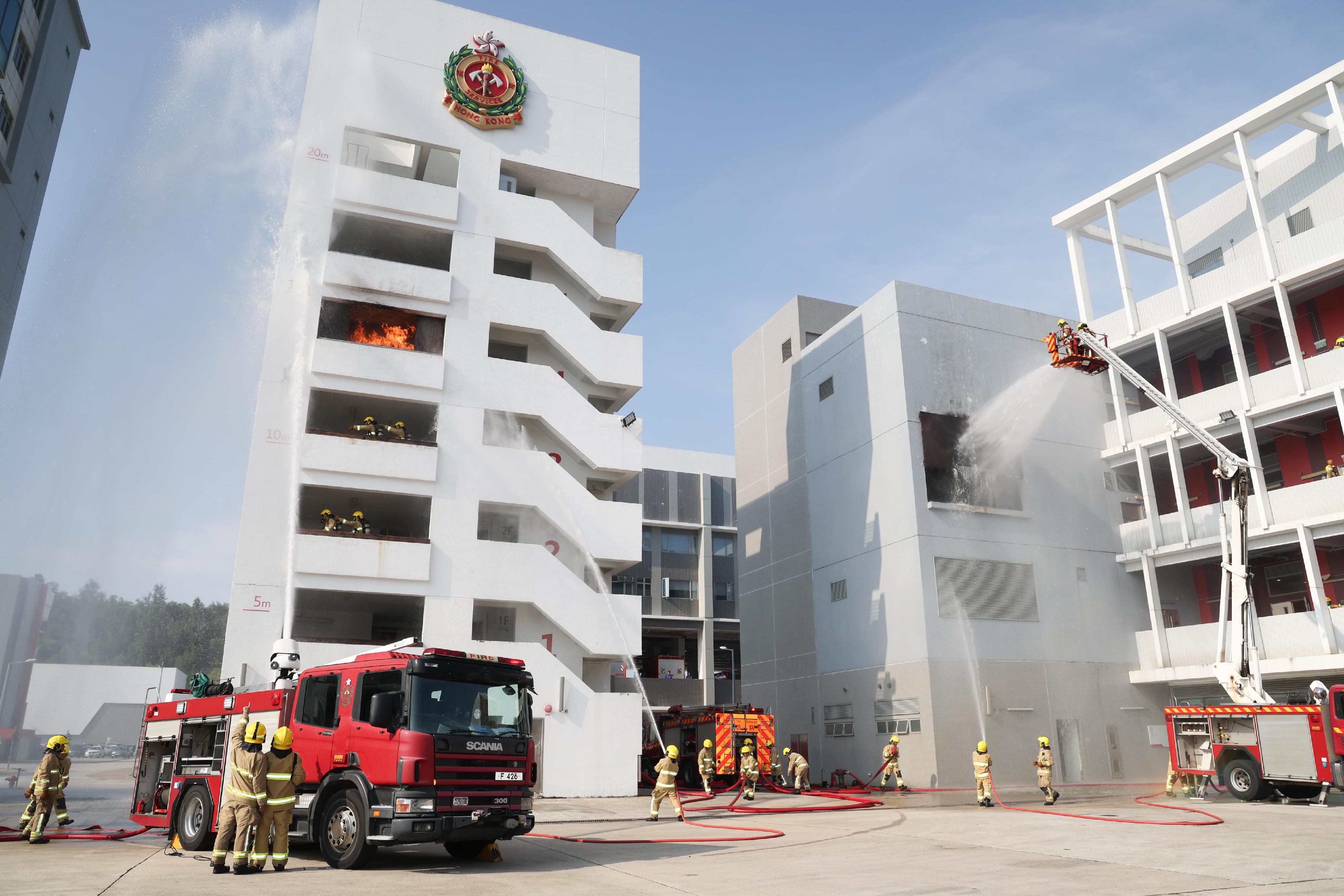 The Deputy Director of Fire Services (Operations), Mr Angus Wong, reviewed the Fire Services passing-out parade at the Fire and Ambulance Services Academy today (September 13). Photo shows graduates demonstrating firefighting techniques.