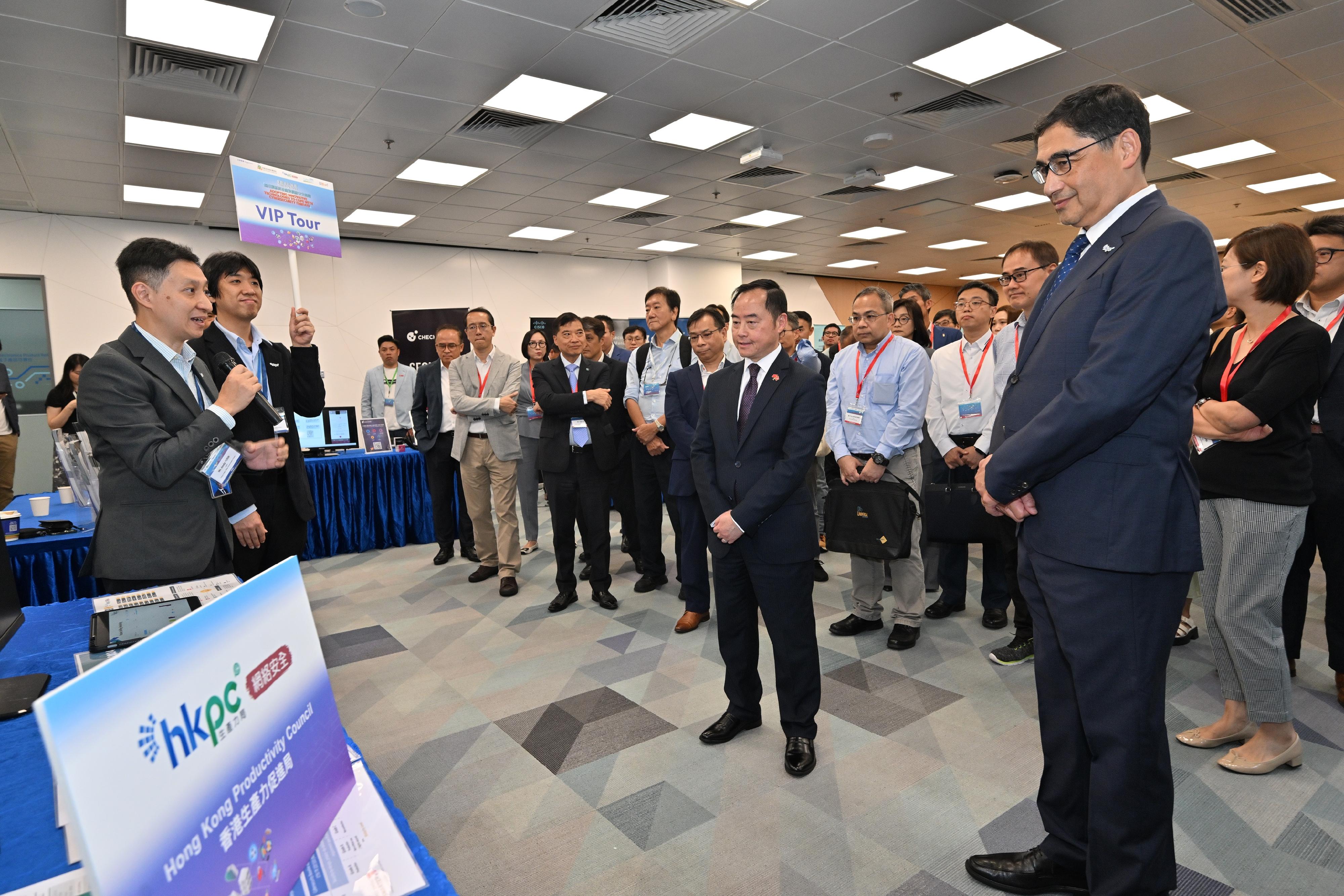 The Commissioner for Digital Policy, Mr Tony Wong (front row, second right), accompanied by the Executive Director of the Hong Kong Productivity Council (HKPC), Mr Mohamed Butt (front row, first right), tours the exhibition booth of the HKPC during the 20th Technology Forum today (September 13).