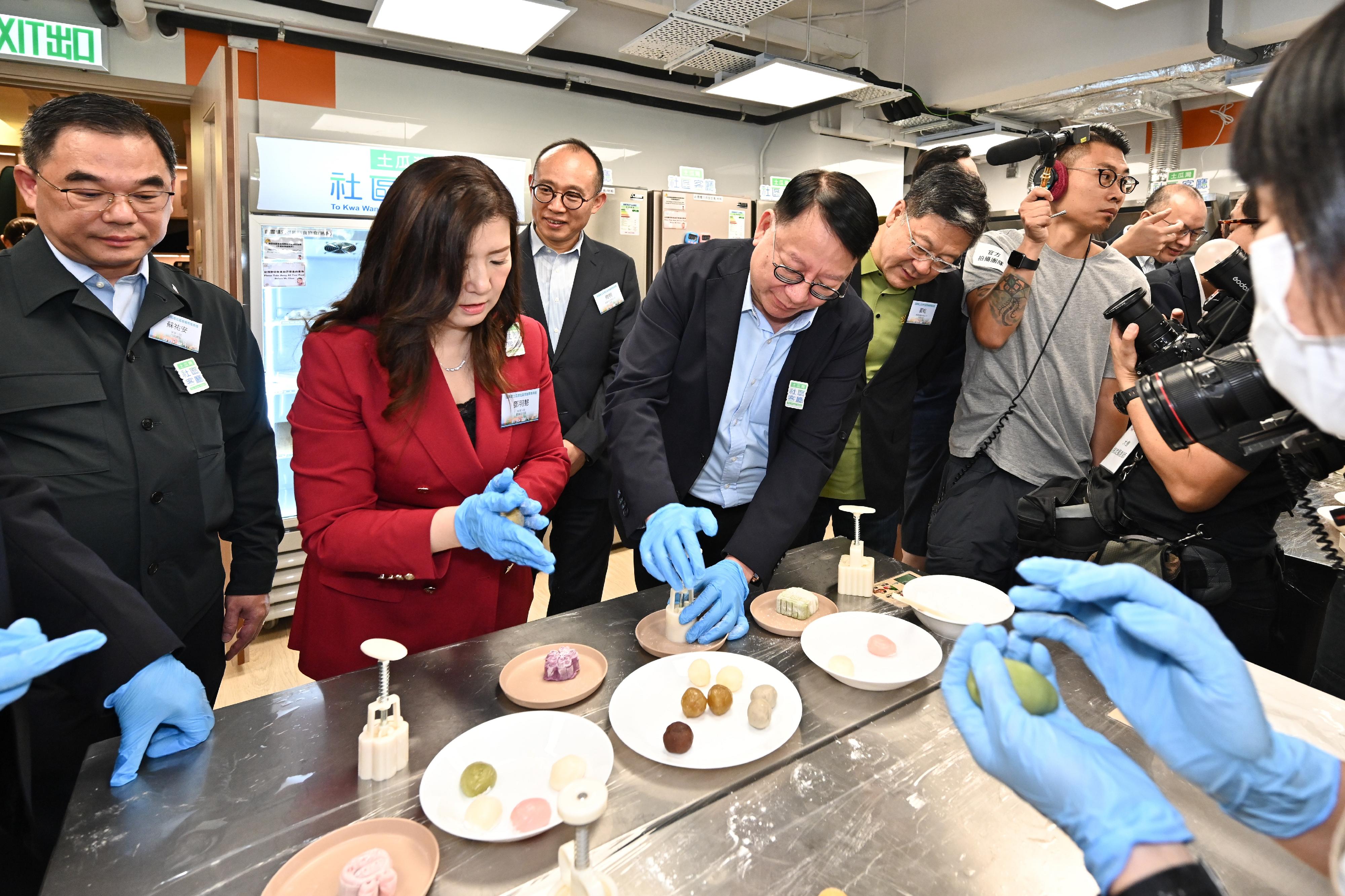 政务司司长陈国基今日（九月十三日）视察土瓜湾社区客厅及主持开幕典礼。中央人民政府驻香港特别行政区联络办公室副主任尹宗华和劳工及福利局局长孙玉菡亦一同参观及主礼开幕礼。图示陈国基（左四）在共享备餐间与受惠家庭制作月饼。