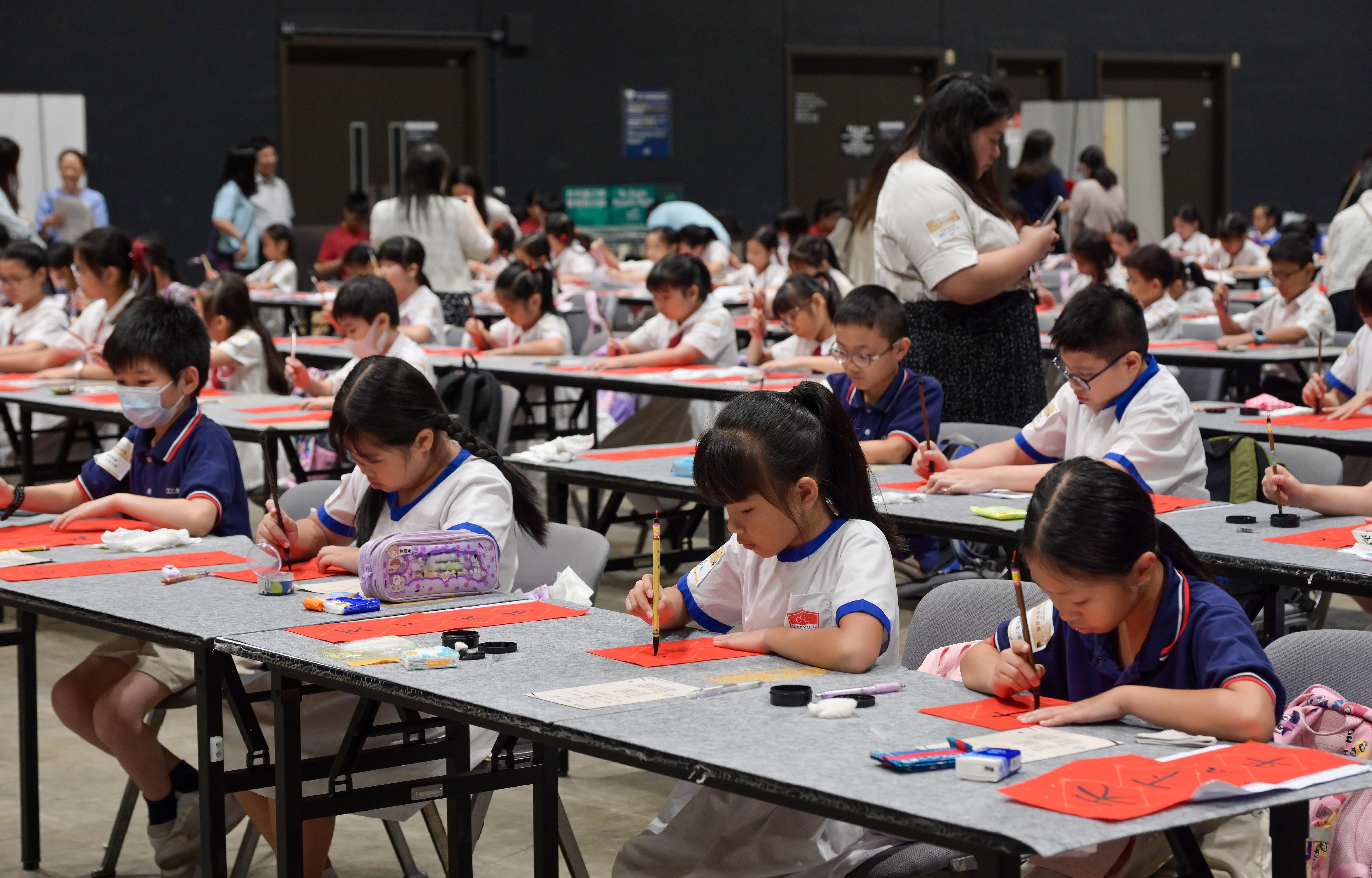 To celebrate the 75th anniversary of the founding of the People's Republic of China, the Education Bureau held the Calligraphy 1 000+, a large-scale primary and secondary school calligraphy event, today (September 14). Photo shows students writing a congratulatory message through the art of calligraphy at the event.