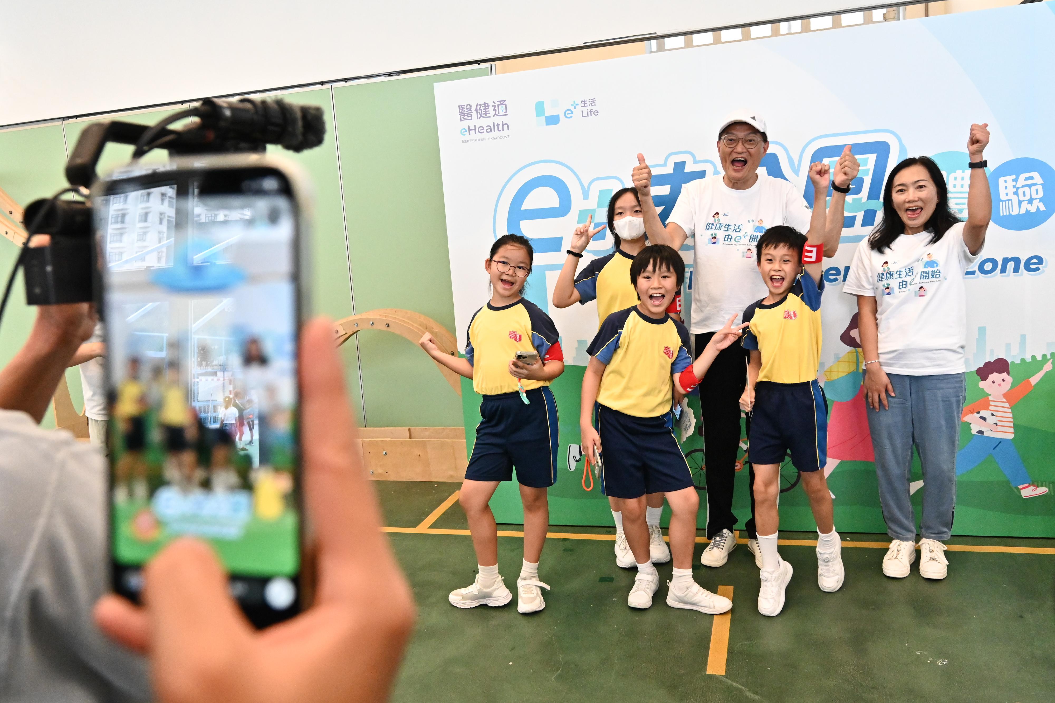 The Secretary for Health, Professor Lo Chung-mau, officiated at the launch ceremony of the first health challenge of eHealth, the "e+ Go to Park" game, today (September 14). Photo shows Professor Lo (back row, second right), and the Deputy Director of Health, Dr Teresa Li (back row, first right), pictured with students using the "e+ Go to Park" social media filter.