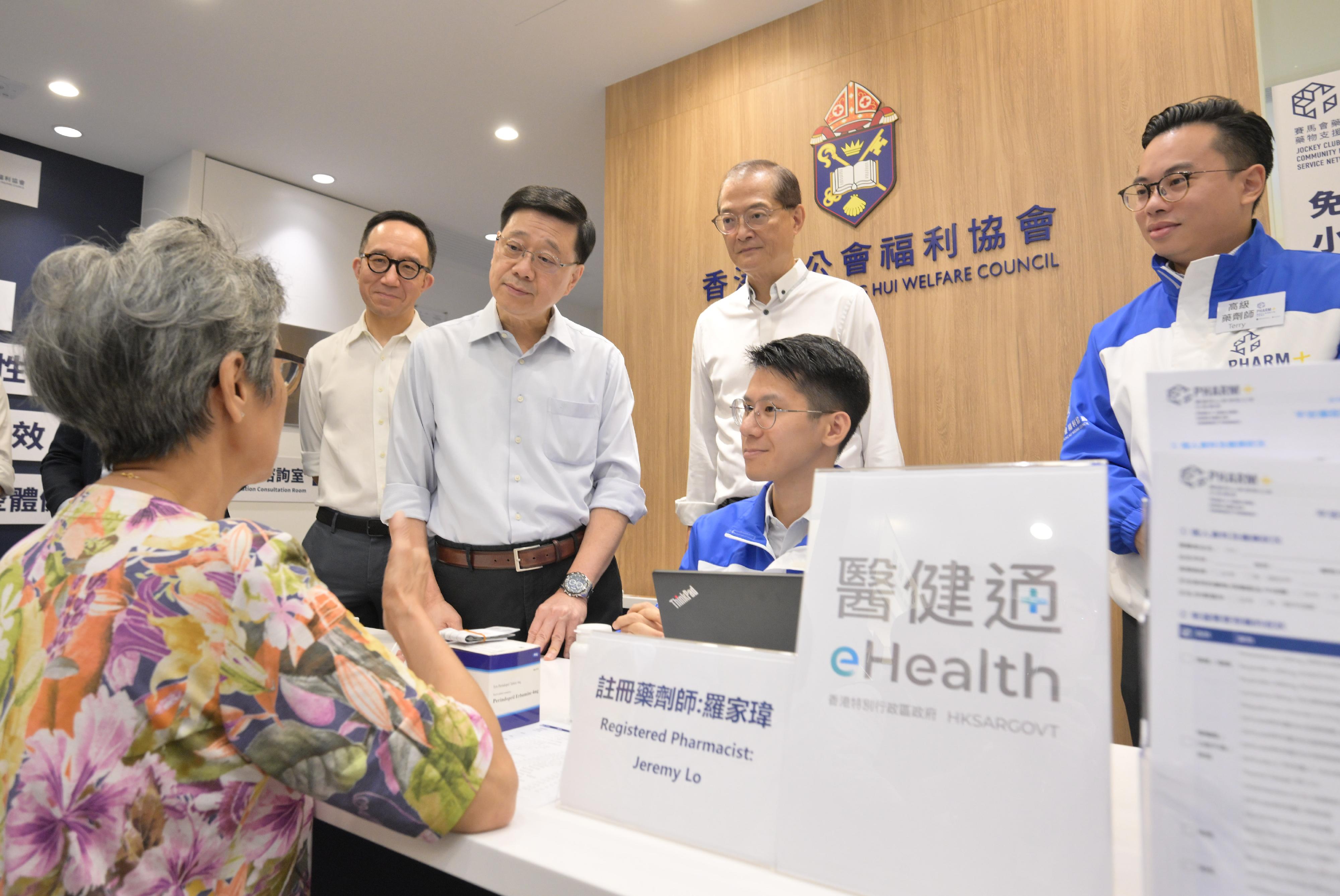 The Chief Executive, Mr John Lee, visited Wong Tai Sin District today (September 14) to gather public views on the upcoming Policy Address. Photo shows Mr Lee (third left) touring a community pharmacy and interacting with a member of the public.