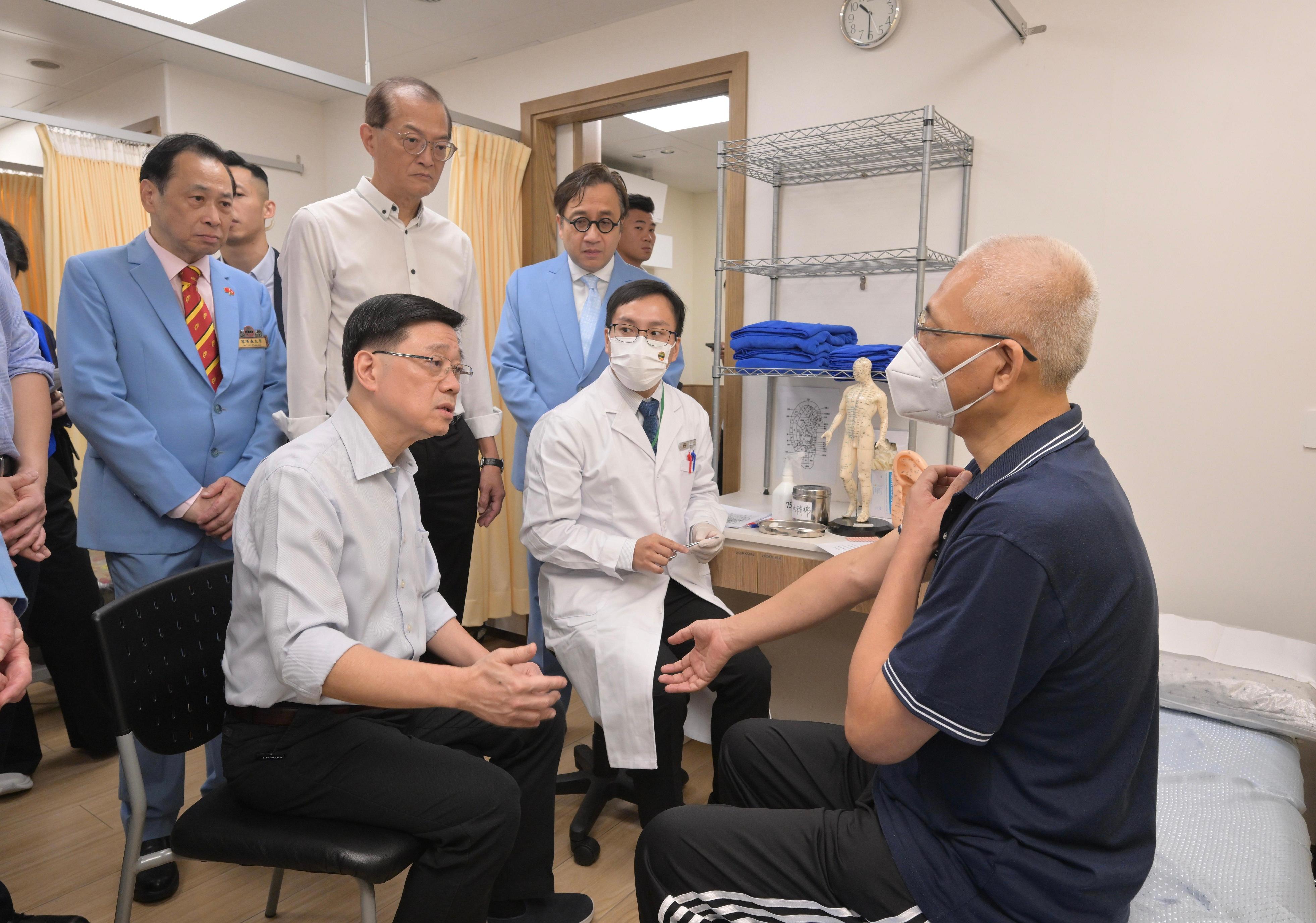 The Chief Executive, Mr John Lee, visited Wong Tai Sin Distrct today (September 14) to gather public views on the upcoming Policy Address. Photo shows Mr Lee (front row, first left) touring a Chinese medicine services centre and interacting with a patient.