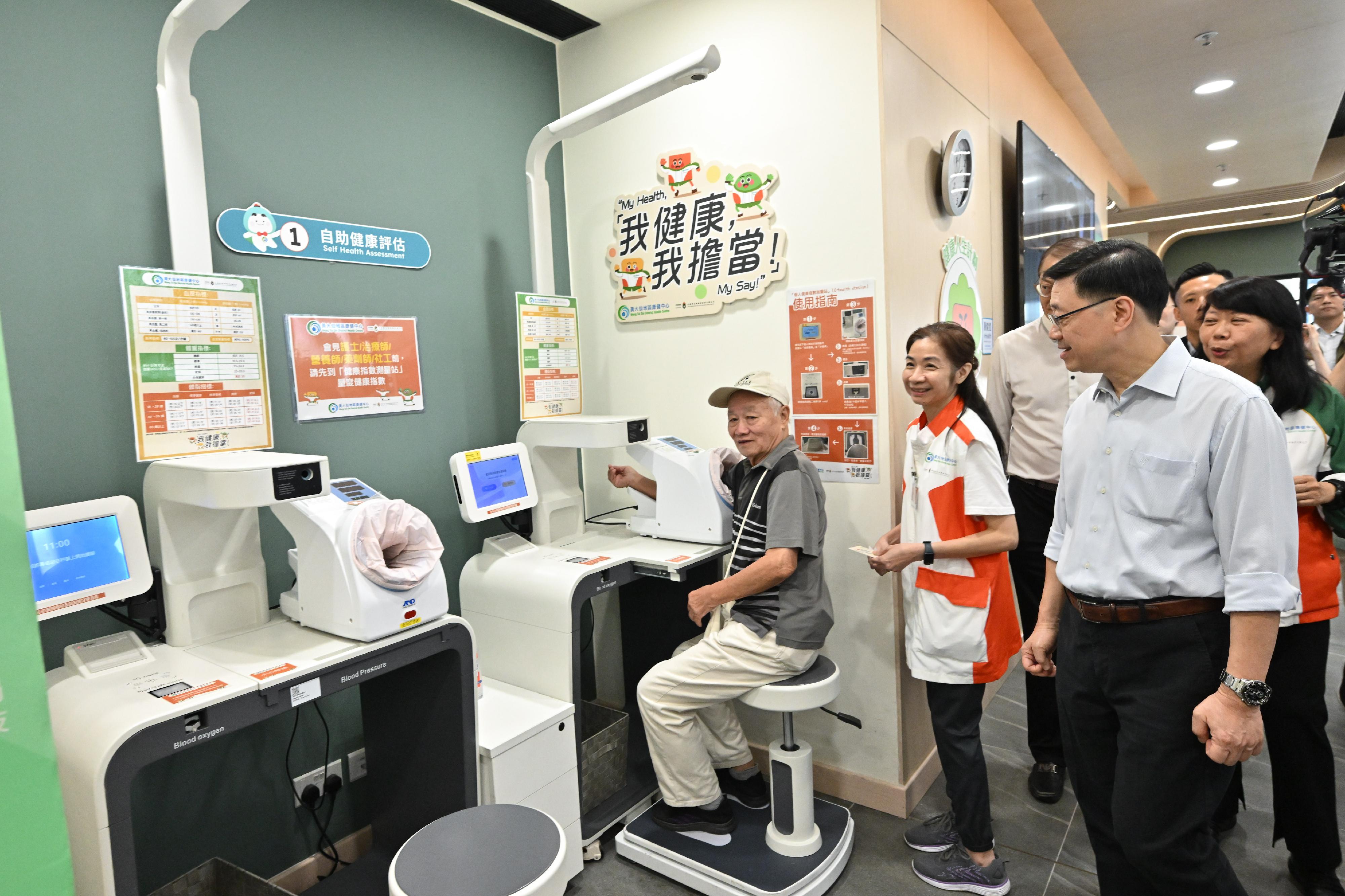 The Chief Executive, Mr John Lee, visited Wong Tai Sin Distrct today (September 14) to gather public views on the upcoming Policy Address. Photo shows Mr Lee (first right) touring a District Health Centre and interacting with a member of the public.