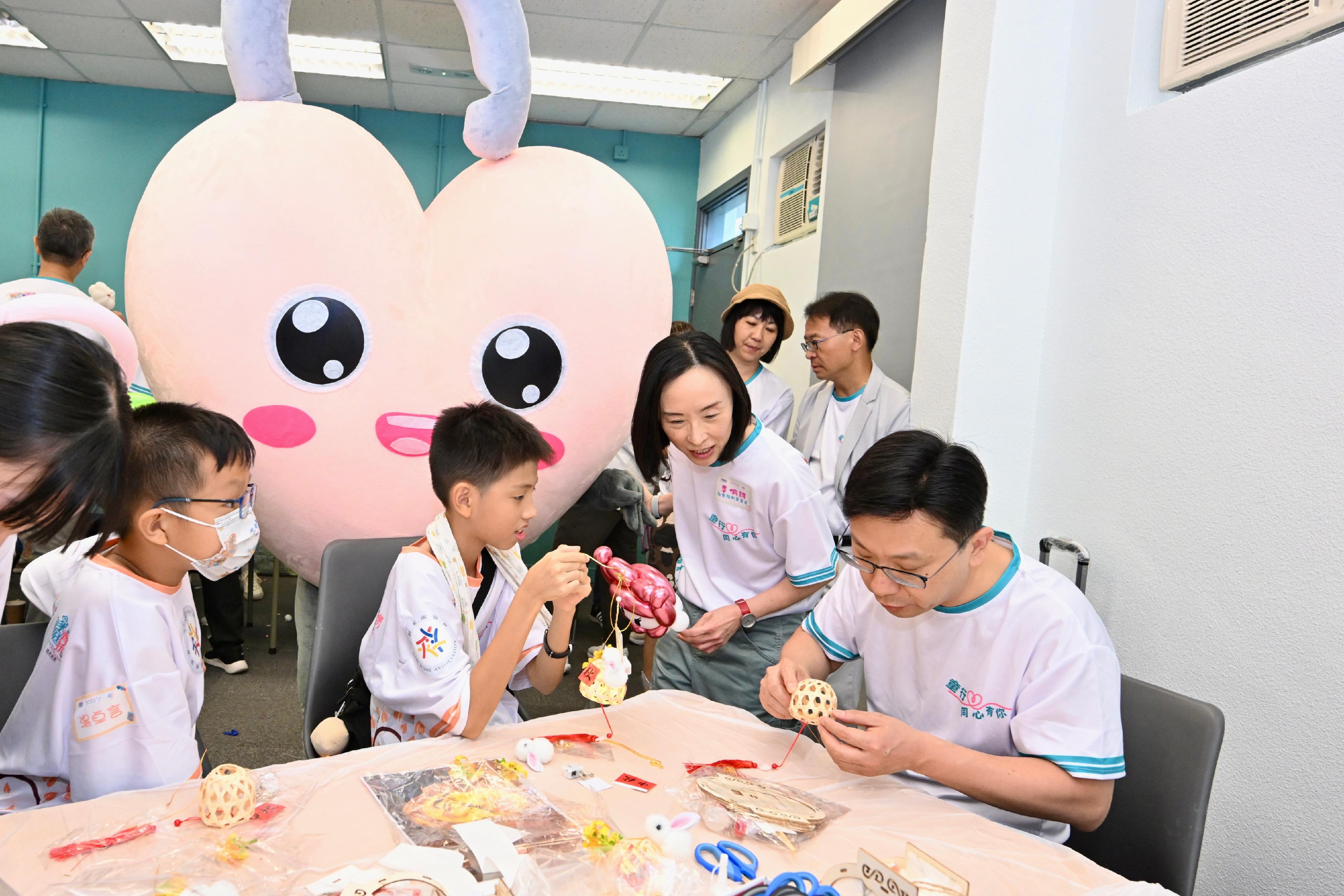 儿童事务委员会、香港警务处和社会福利署今日（九月十四日）在八乡少年警讯永久活动中心暨青少年综合训练营合办「童行․同心․有你」一家大细「营」中秋持份者交流活动。劳工及福利局局长兼儿童事务委员会副主席孙玉菡、警务处处长萧泽颐及社会福利署署长李佩诗一同出席活动。图示孙玉菡（右一）和李佩诗（右二）与儿童一起参与花灯工作坊。
