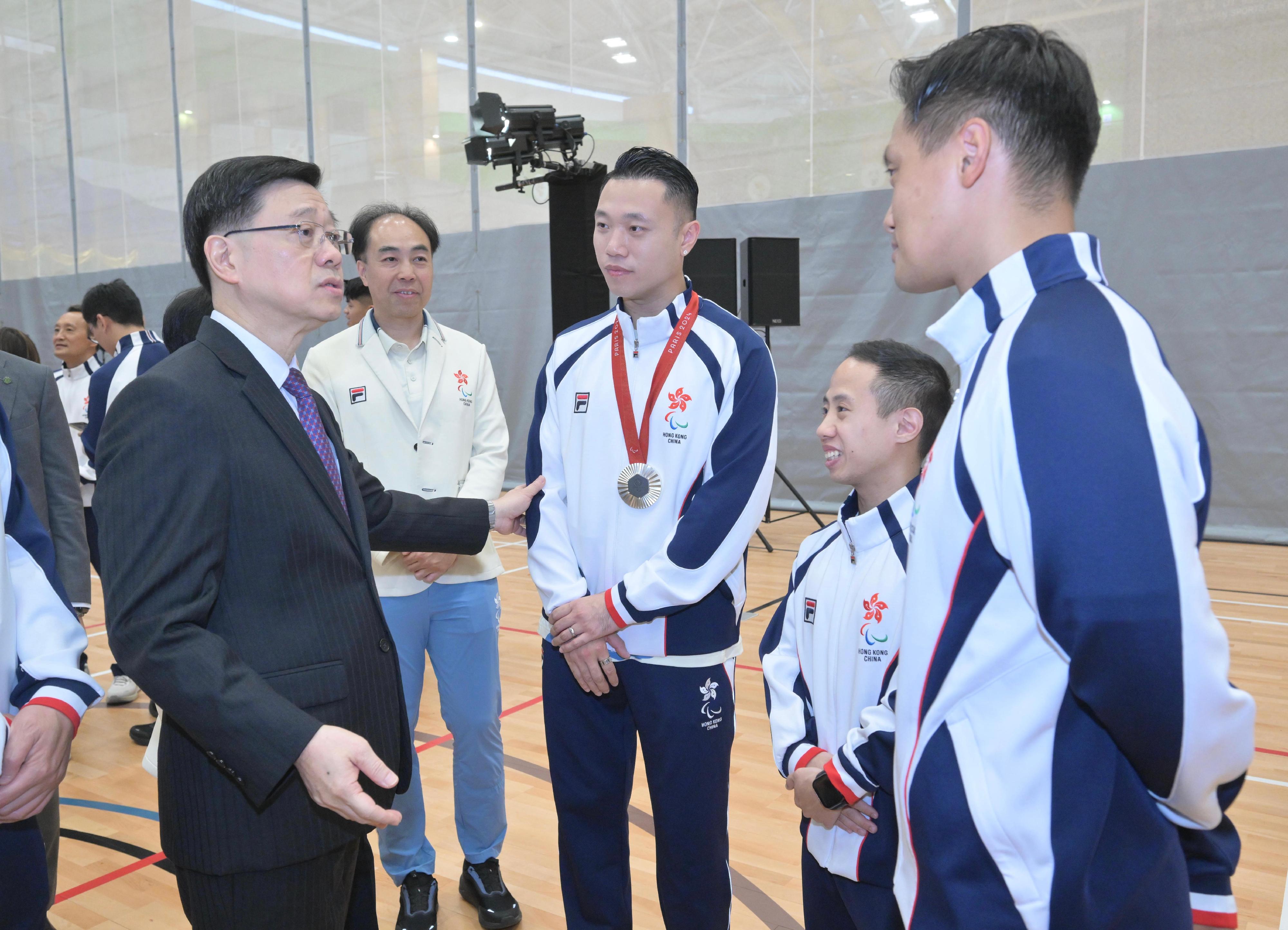 行政长官李家超今日（九月十六日）出席巴黎2024残疾人奥运会中国香港代表团返港欢迎仪式。图示李家超（左一）与参赛的运动员交谈。