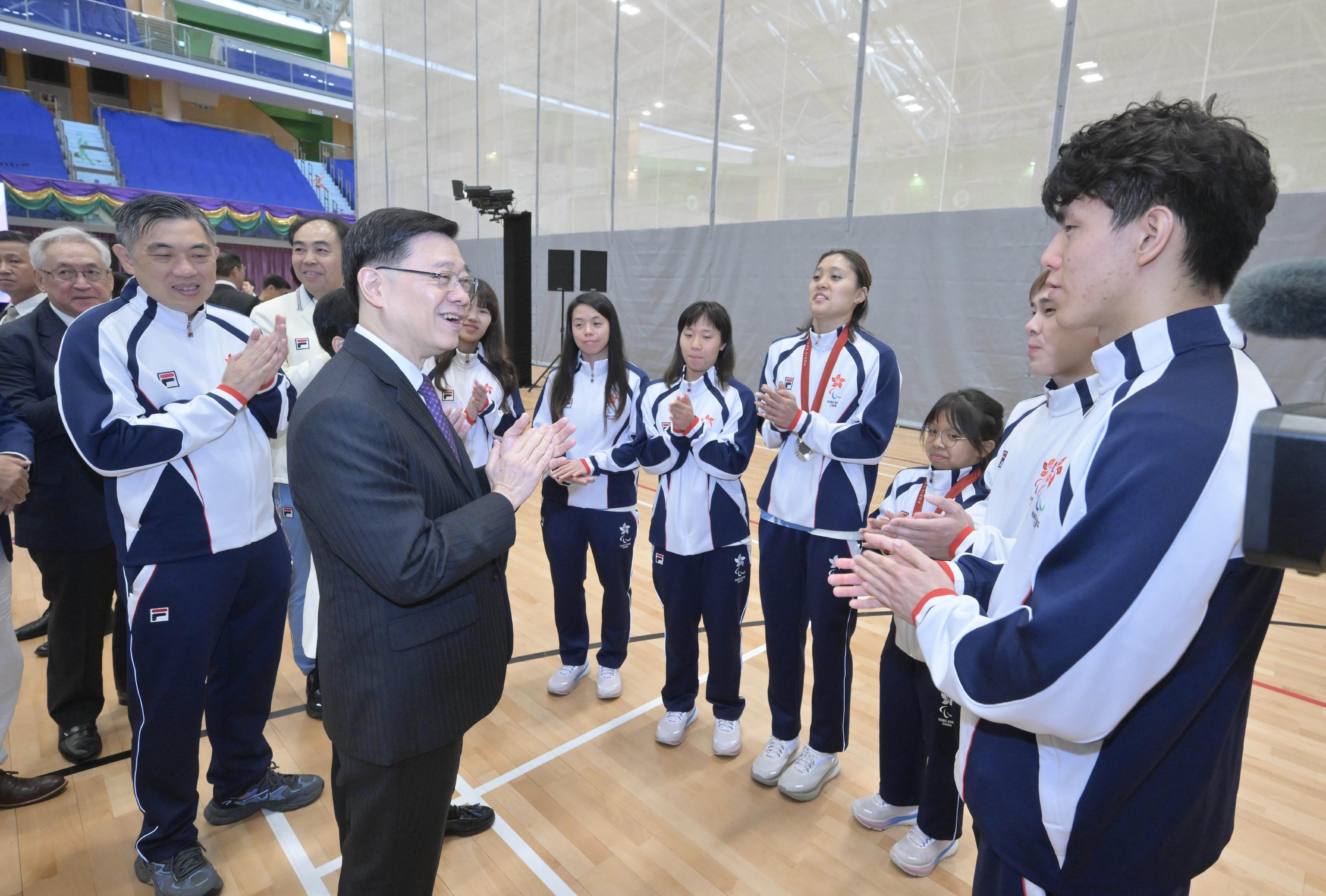 行政长官李家超今日（九月十六日）出席巴黎2024残疾人奥运会中国香港代表团返港欢迎仪式。图示李家超（左四）与参赛的运动员交谈。