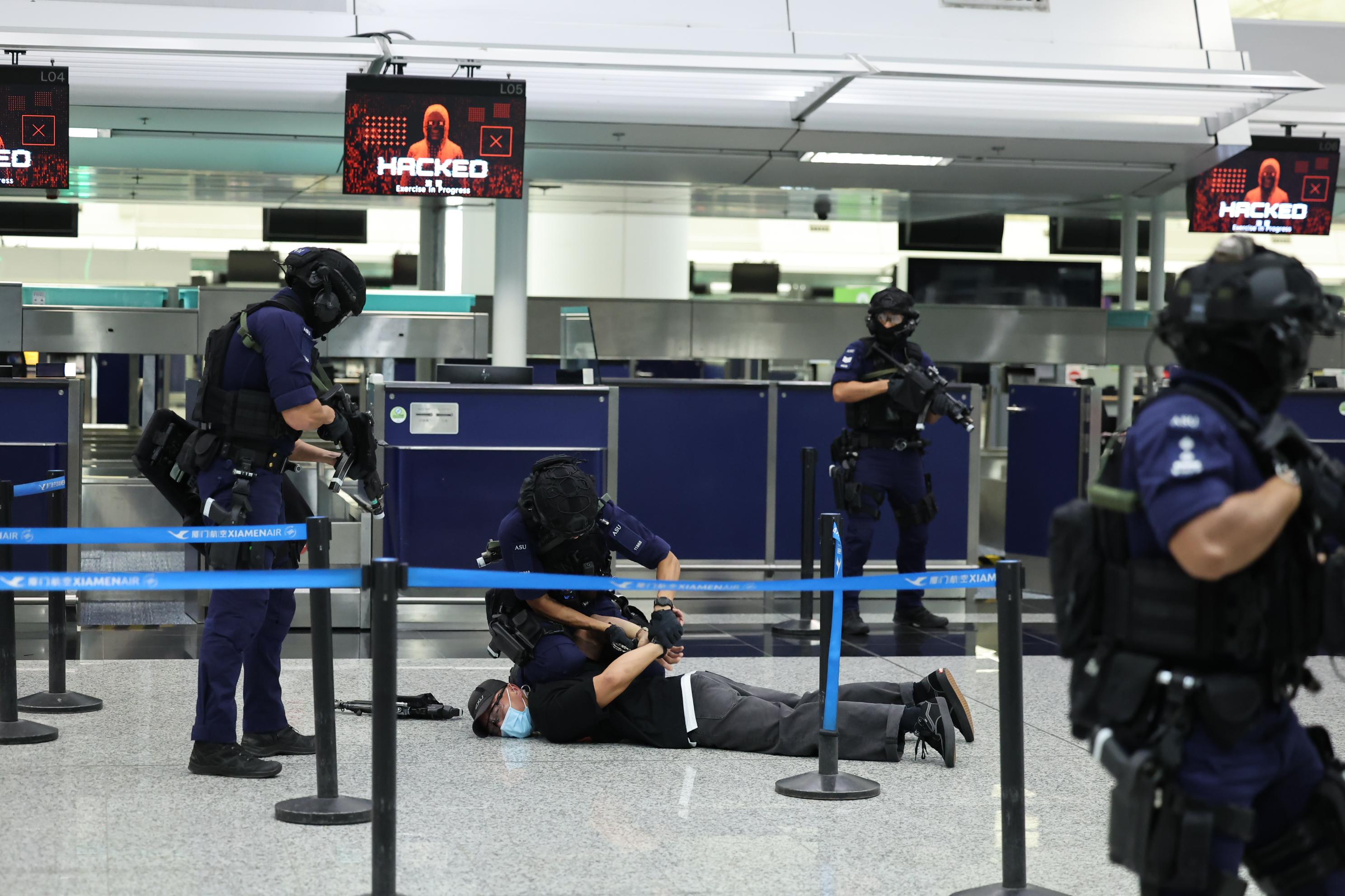 The Cyber Security and Technology Crime Bureau of the Hong Kong Police Force held the Counter Cyber and Physical Terrorism Joint Exercise 2024 codenamed BATTLEAIR in collaboration with the INTERPOL and the Macao Judiciary Police today (September 21). Photo shows officers of the Airport Security Unit subduing an armed terrorist.
