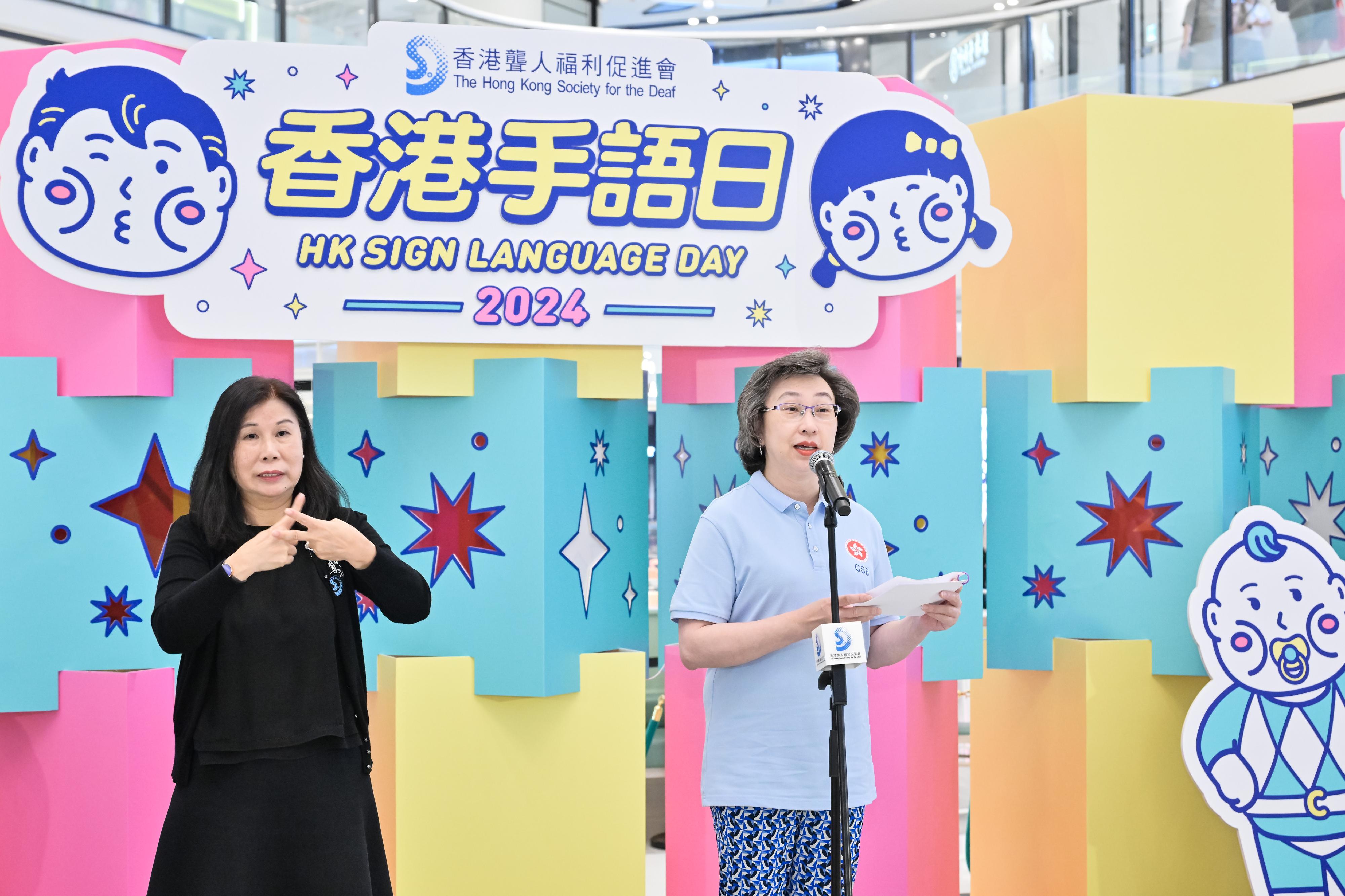 The Civil Service Bureau's Volunteer Team today (September 22) helped the Hong Kong Society for the Deaf to organise "Hong Kong Sign Language Day 2024" games at a shopping mall in Tai Wai, where members of the public could learn sign language and play games to encourage them to communicate more with the hearing impaired. Photo shows the Secretary for Civil Service, Mrs Ingrid Yeung (right), delivering a speech at the opening ceremony of the activity.