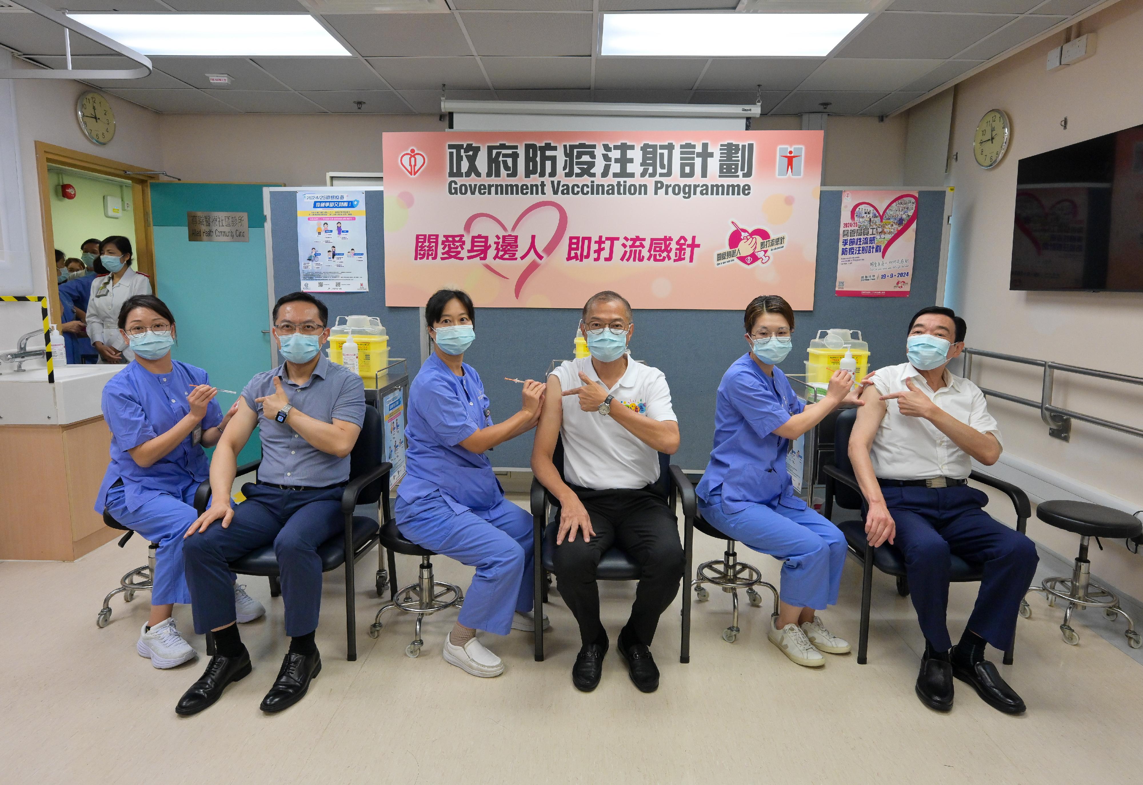 The Secretary for Health, Professor Lo Chung-mau (third right); the Director of Health, Dr Ronald Lam (second left); and the Chairman of the Hospital Authority, Mr Henry Fan (first right), receive vaccinations against seasonal influenza and COVID-19 at Sai Wan Ho General Out-patient Clinic today (September 24).