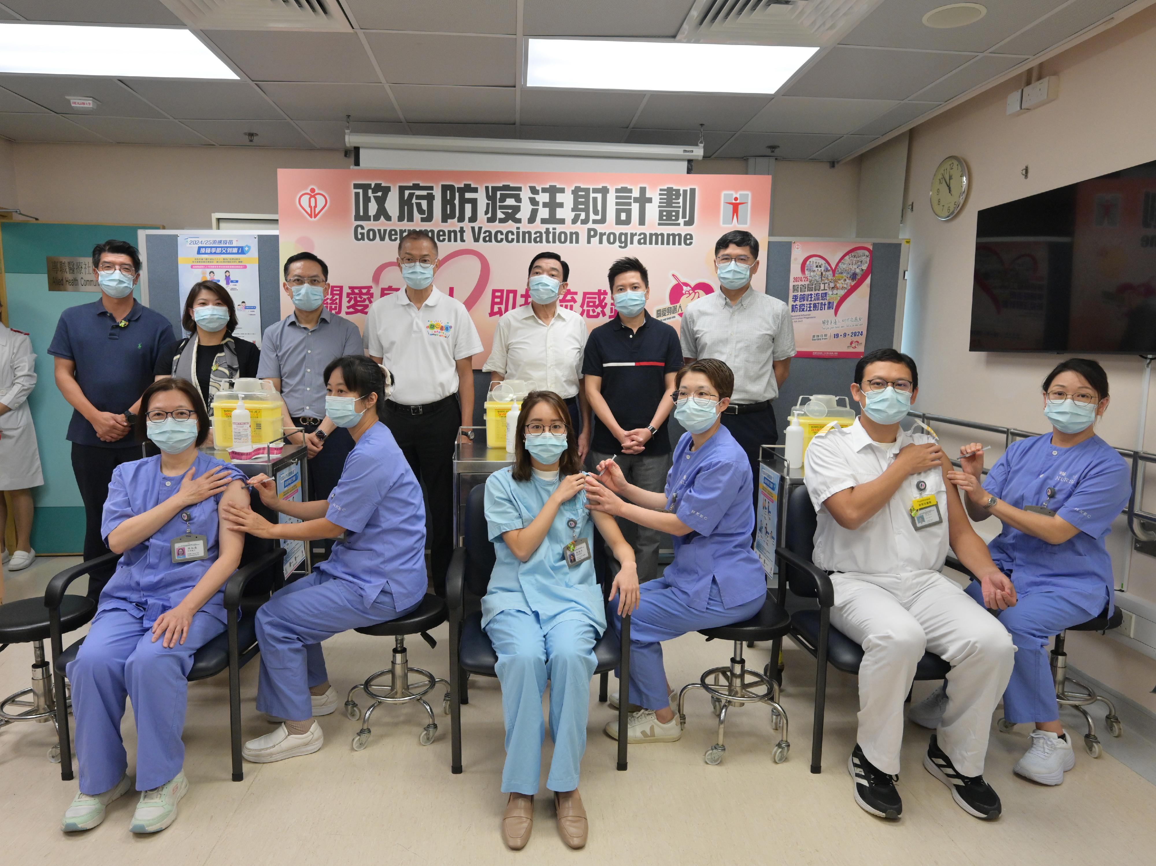 The Secretary for Health, Professor Lo Chung-mau (back row, centre); the Under Secretary for Health, Dr Libby Lee (back row, second left); the Director of Health, Dr Ronald Lam (back row, third left); the Controller of the Centre for Health Protection of the Department of Health, Dr Edwin Tsui (back row, second right); the Commissioner for Primary Healthcare of the Health Bureau, Dr Pang Fei-chau (back row, first left); the Chairman of the Hospital Authority (HA), Mr Henry Fan (back row, third right); and the Chief Executive of the HA, Dr Tony Ko (back row, first right), look on as frontline healthcare workers receive seasonal influenza vaccination at Sai Wan Ho General Out-patient Clinic today (September 24).