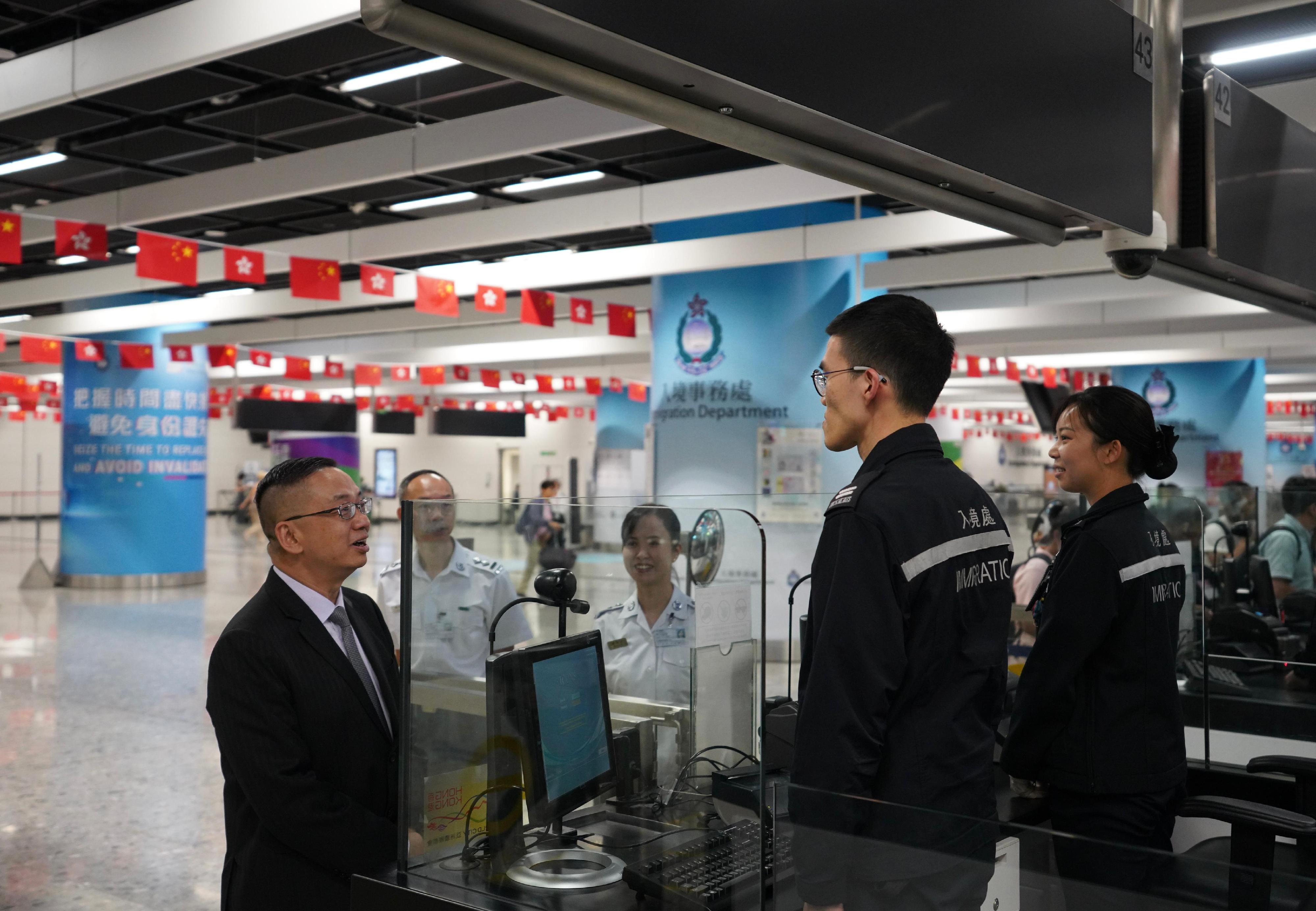 The Director of Immigration, Mr Benson Kwok, today (September 24) visited the Express Rail Link West Kowloon Control Point to inspect the preparation work of the department in coping with passenger traffic during the National Day festive period. Photo shows Mr Kwok (left) showing support for a frontline officer at the Express Rail Link West Kowloon Control Point.