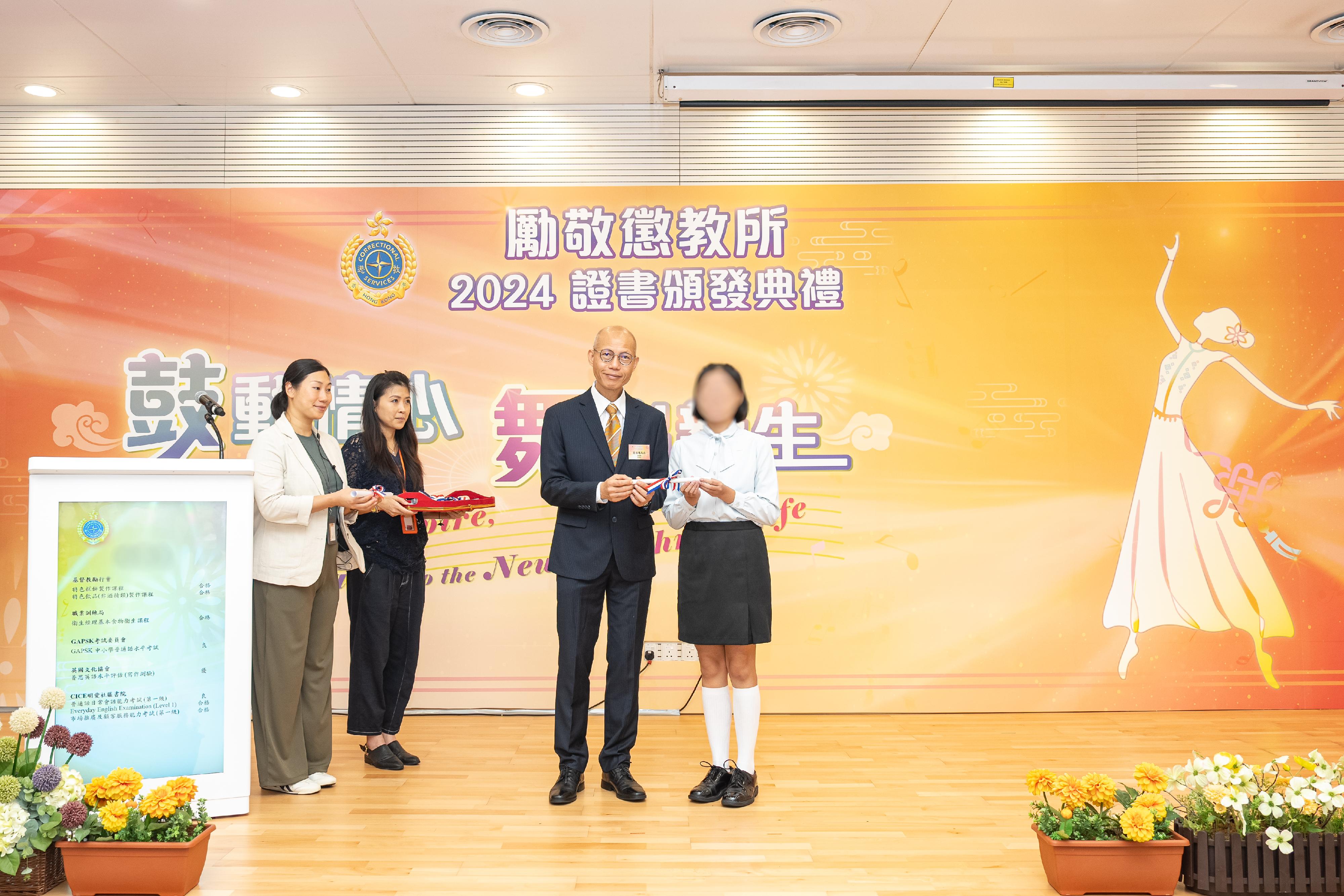 Young persons in custody at Lai King Correctional Institution of the Correctional Services Department were presented with certificates at a ceremony today (September 25) in recognition of their efforts and achievements in studies and vocational examinations. Photo shows the Chairman of Tung Sin Tan, Mr Ha Tak-kin (second right), presenting certificates to a young person in custody.