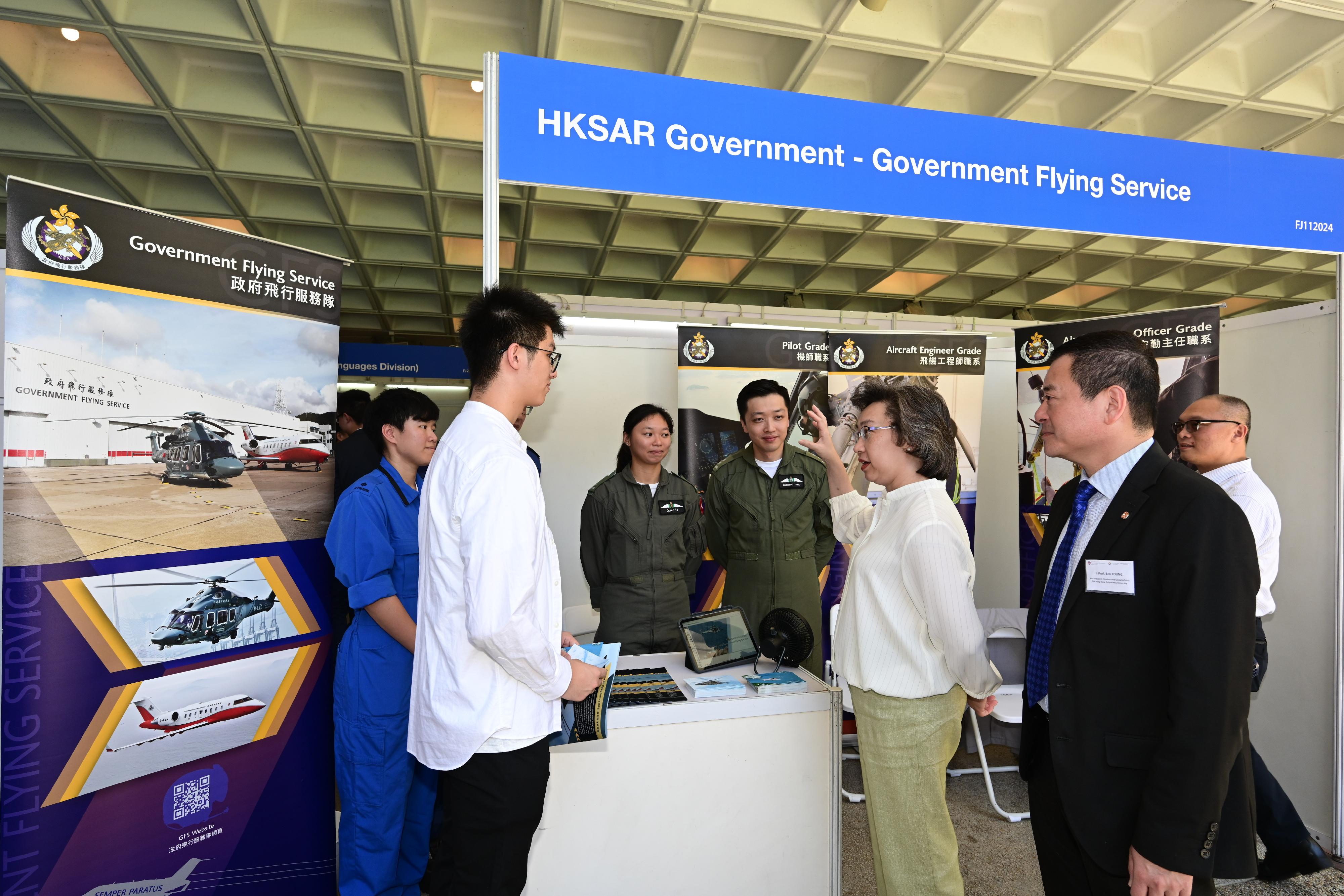 The Secretary for the Civil Service, Mrs Ingrid Yeung, attended the Government Career Fair at the Hong Kong Polytechnic University (PolyU) today (September 26). Photo shows Mrs Yeung (third right) chatting with a student, who wants to become a pilot after graduation, at the Government Flying Service booth. Looking on is the Vice President (Student and Global Affairs) of PolyU, Professor Ben Young (second right).
